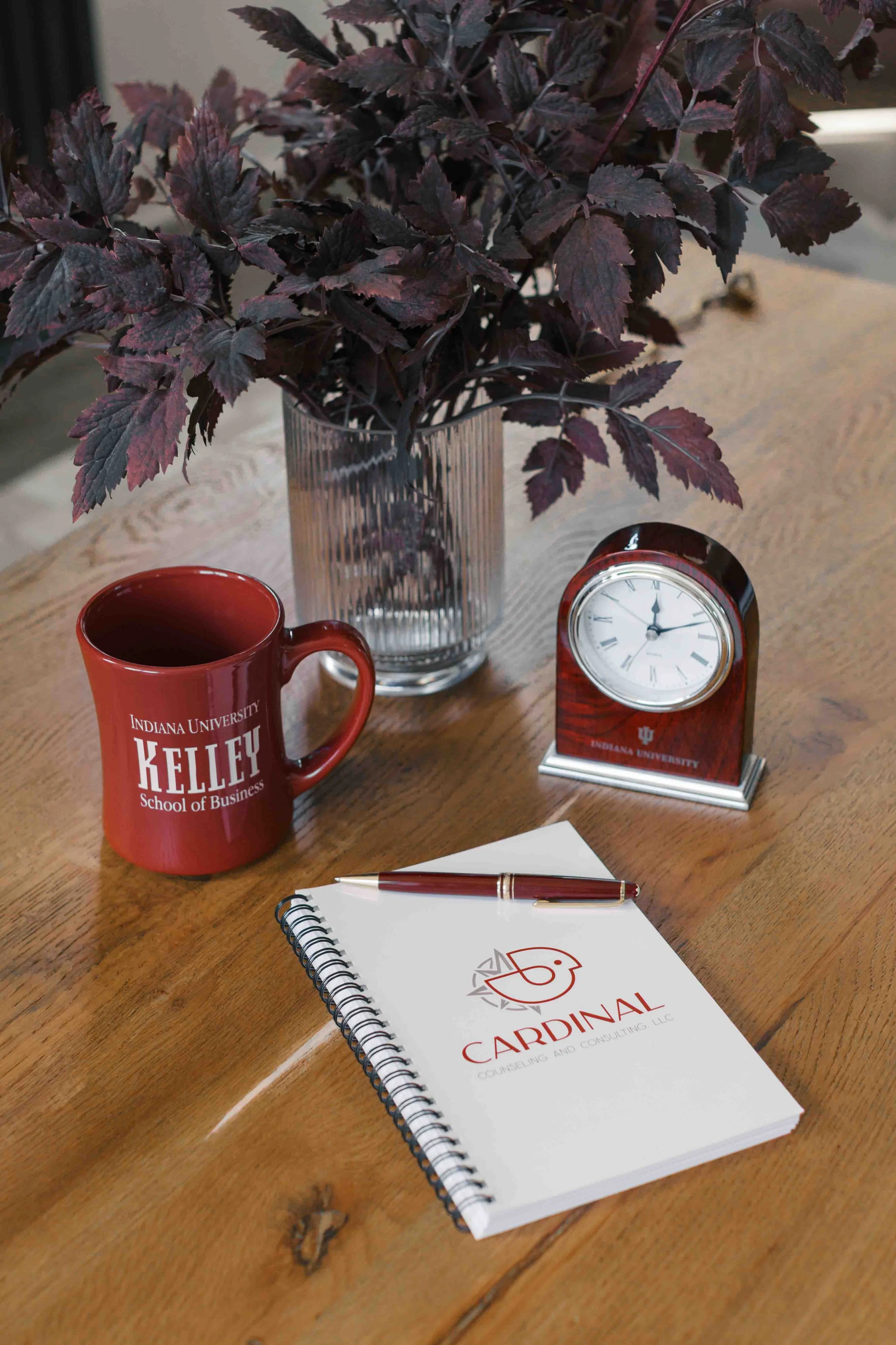 Kelley Mug, IU Clock, Cardinal Counseling notebook on a table