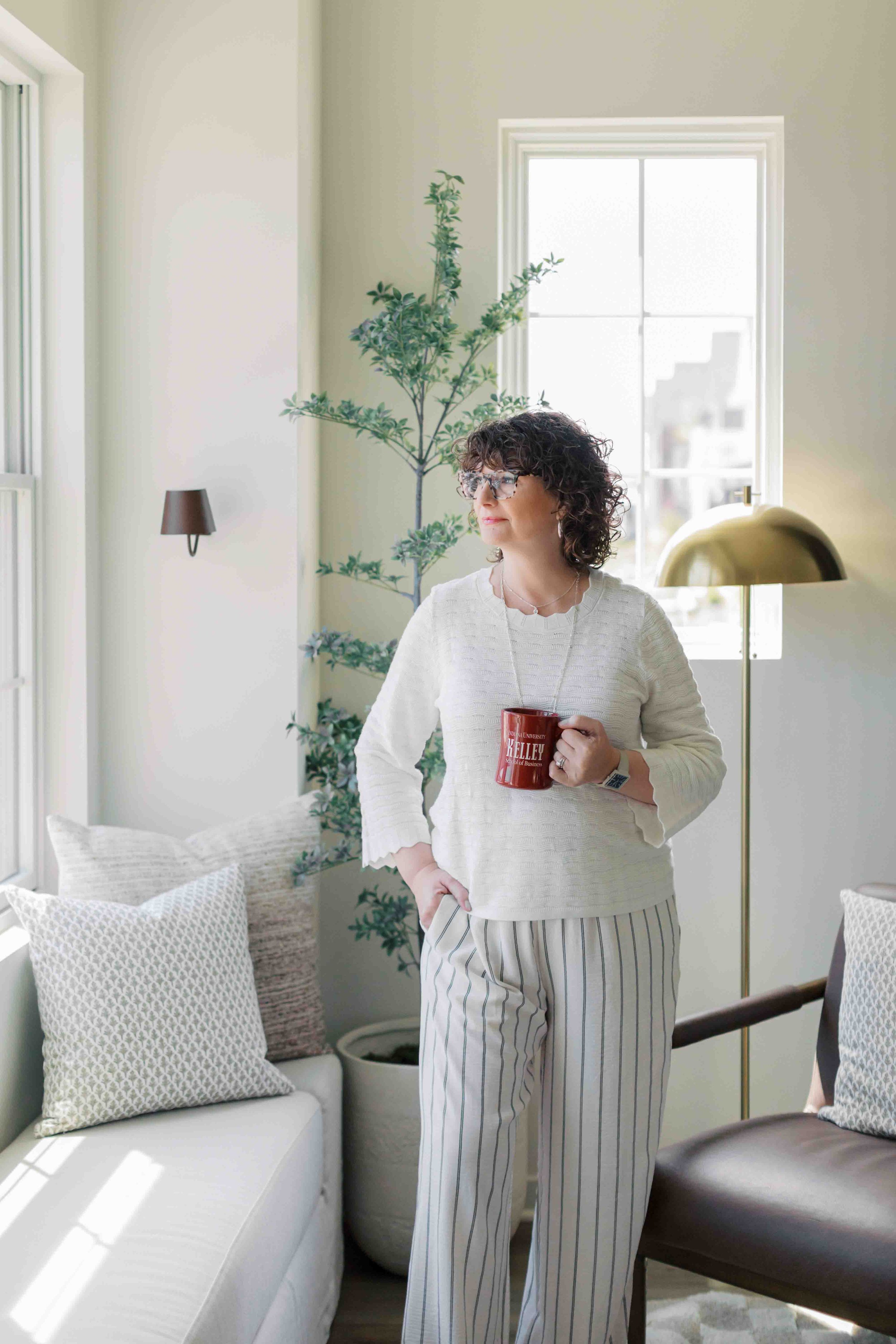 Nichole Alspaugh Williams therapist in Bloomington looking out a window with a cup of coffee