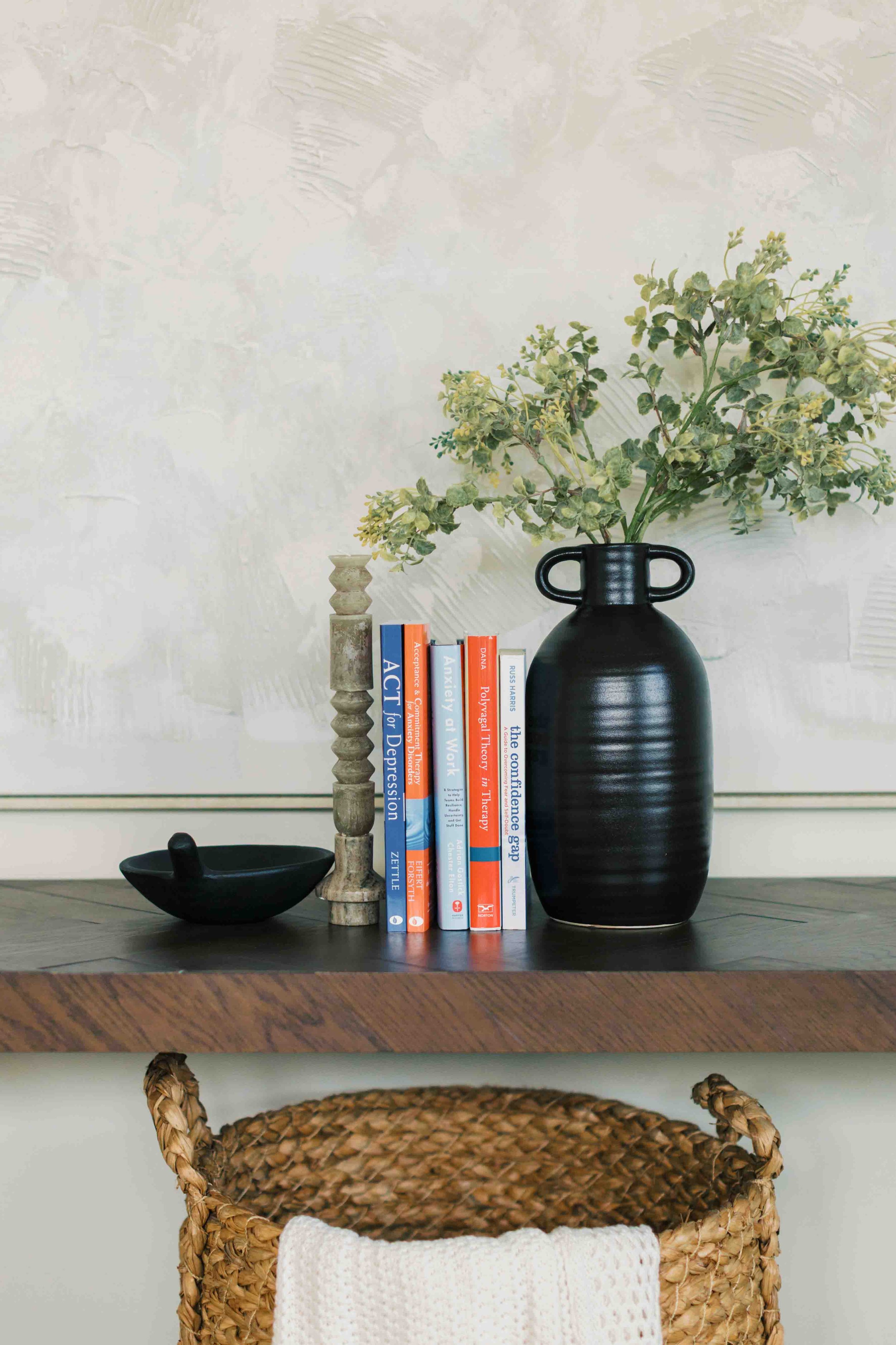 row of therapy books representing work stress, imposter syndrome, and career transitions