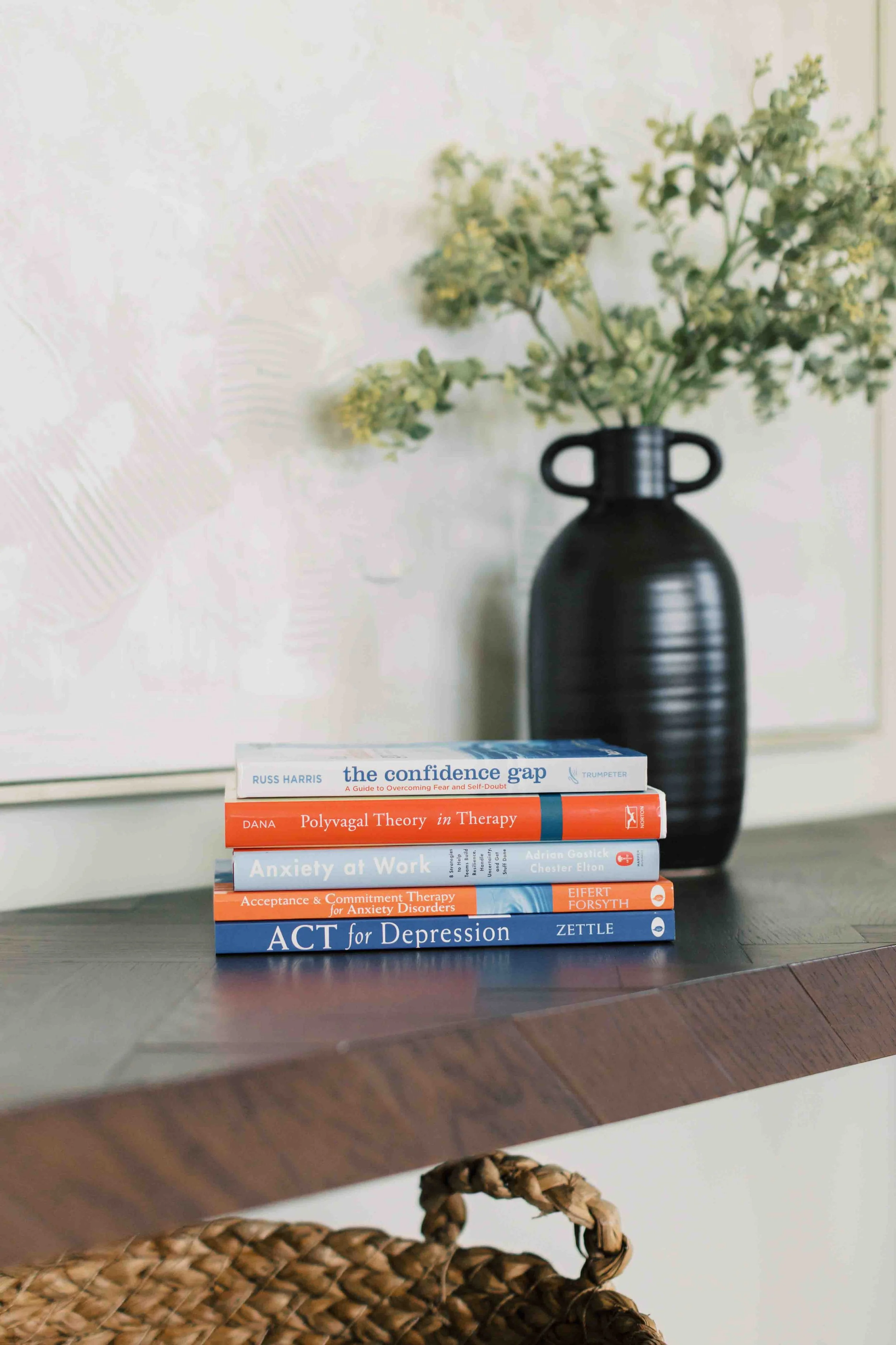 row of therapy books representing work stress, imposter syndrome, and career transitions