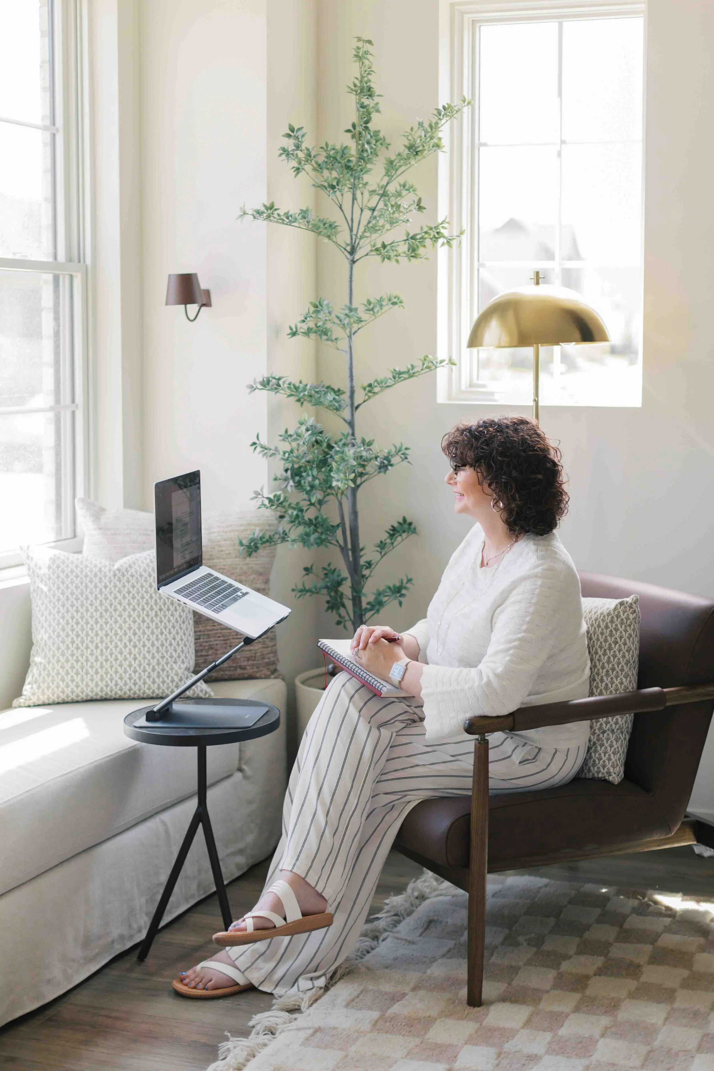 Nichole Alspaugh Williams therapist in Bloomington sitting by a window with a computer on a virtual therapy call