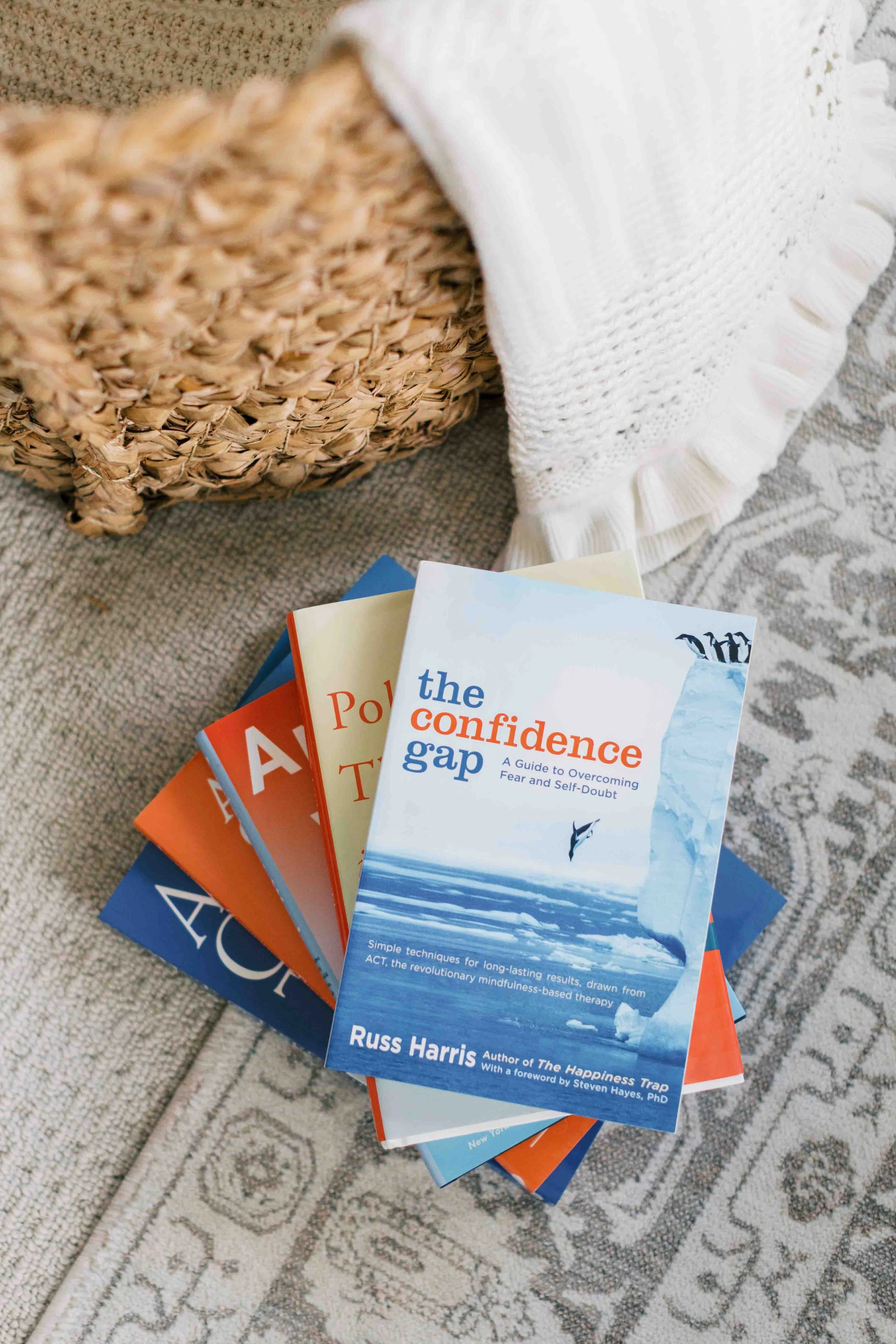 Stack of books with an imposter syndrome book on top