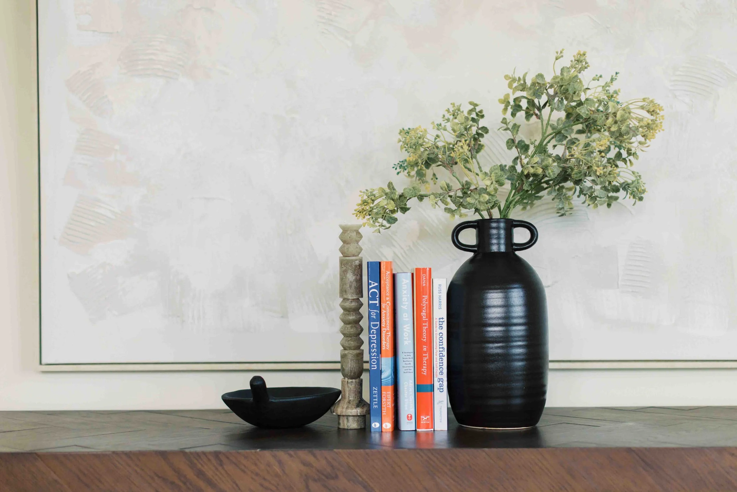 Row of work stress, imposter syndrome, anxiety books on a table