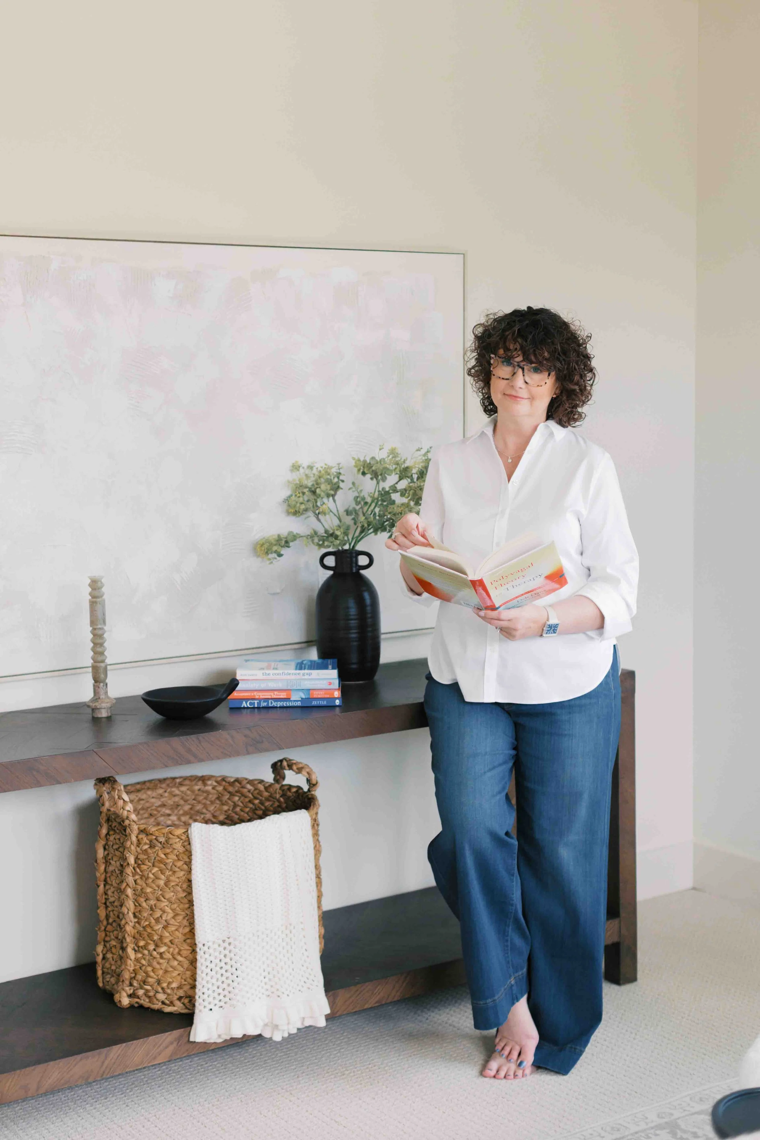 Nichole Williams therapist in Bloomington standing by table and reading book