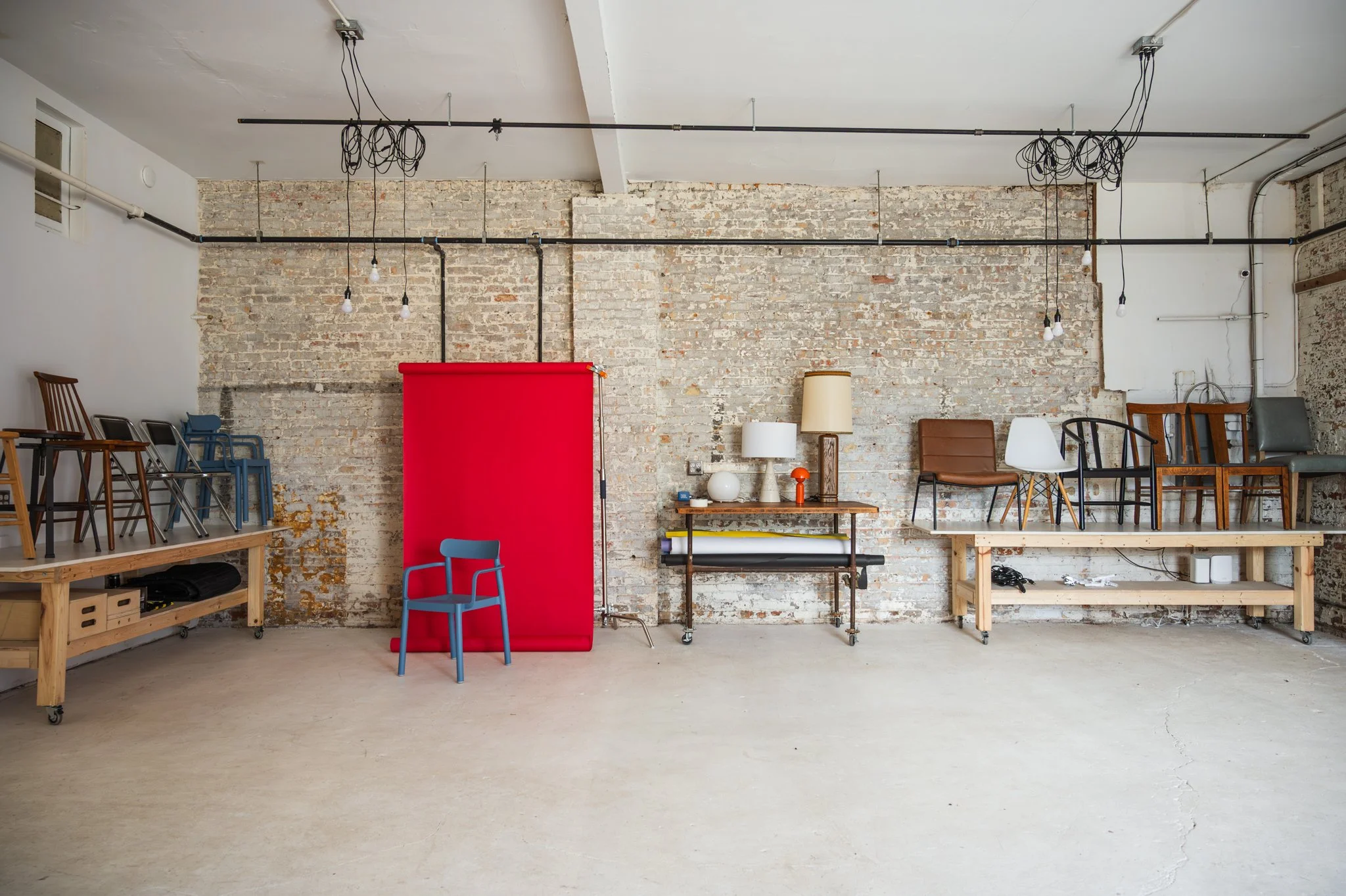 AH AH's back studio area with distressed brick walls, and various chairs and furniture from the in-house prop collection.