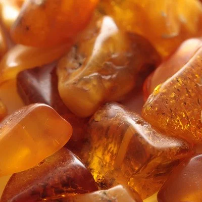 Close-up of amber-colored chewing gum pieces with glossy and translucent textures.