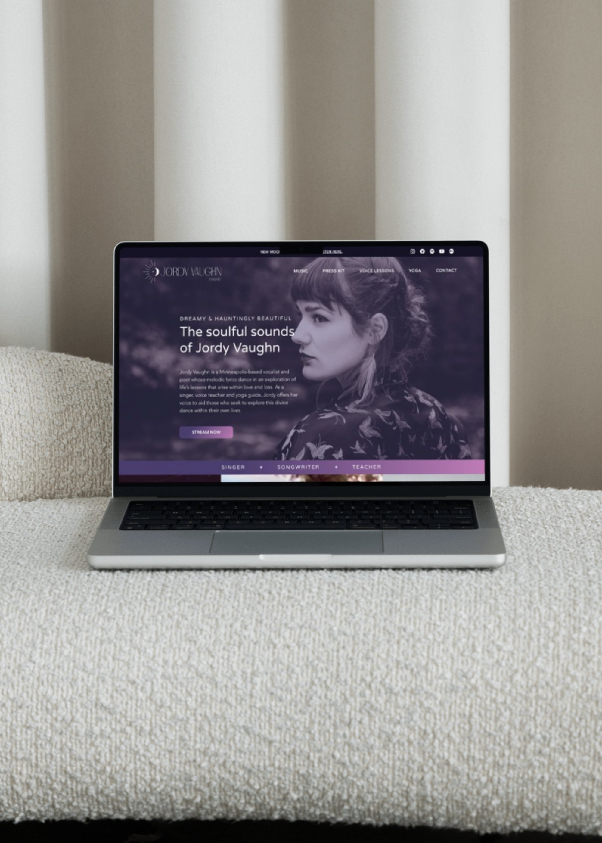 A mockup of the Jordy Vaughn Music website design on a laptop on a white couch to represent custom website design services.