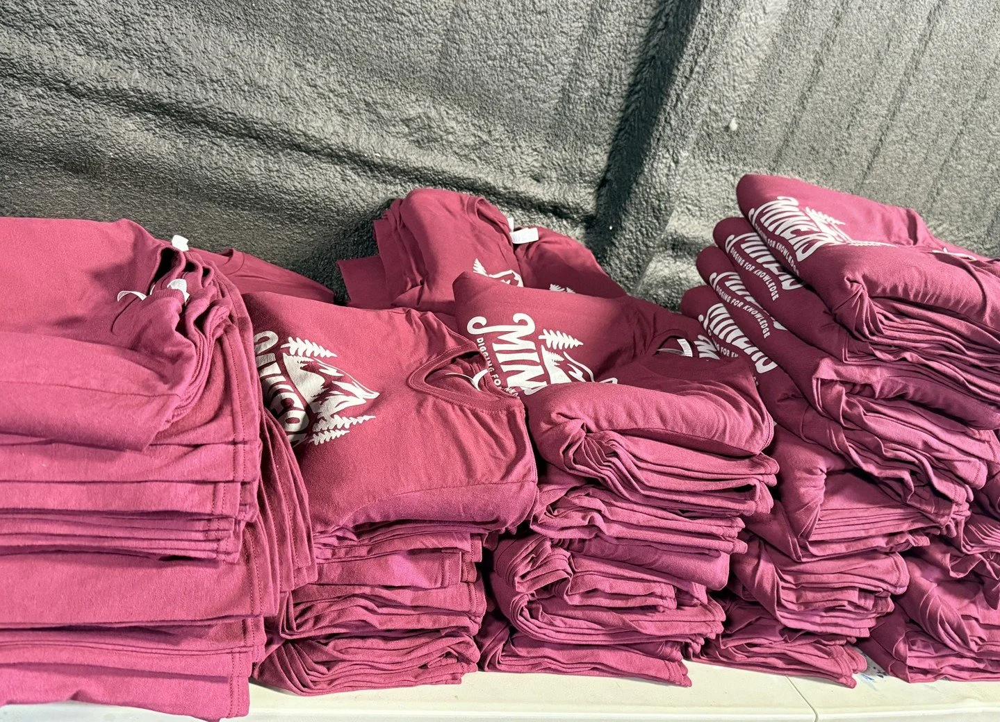 Every shirt tells a story—here’s proof. 
What’s better than stacks of fresh tees? Stacks of custom tees made for a crew that puts their heart into everything they do. Our client wanted gear that felt as bold as their message, so we