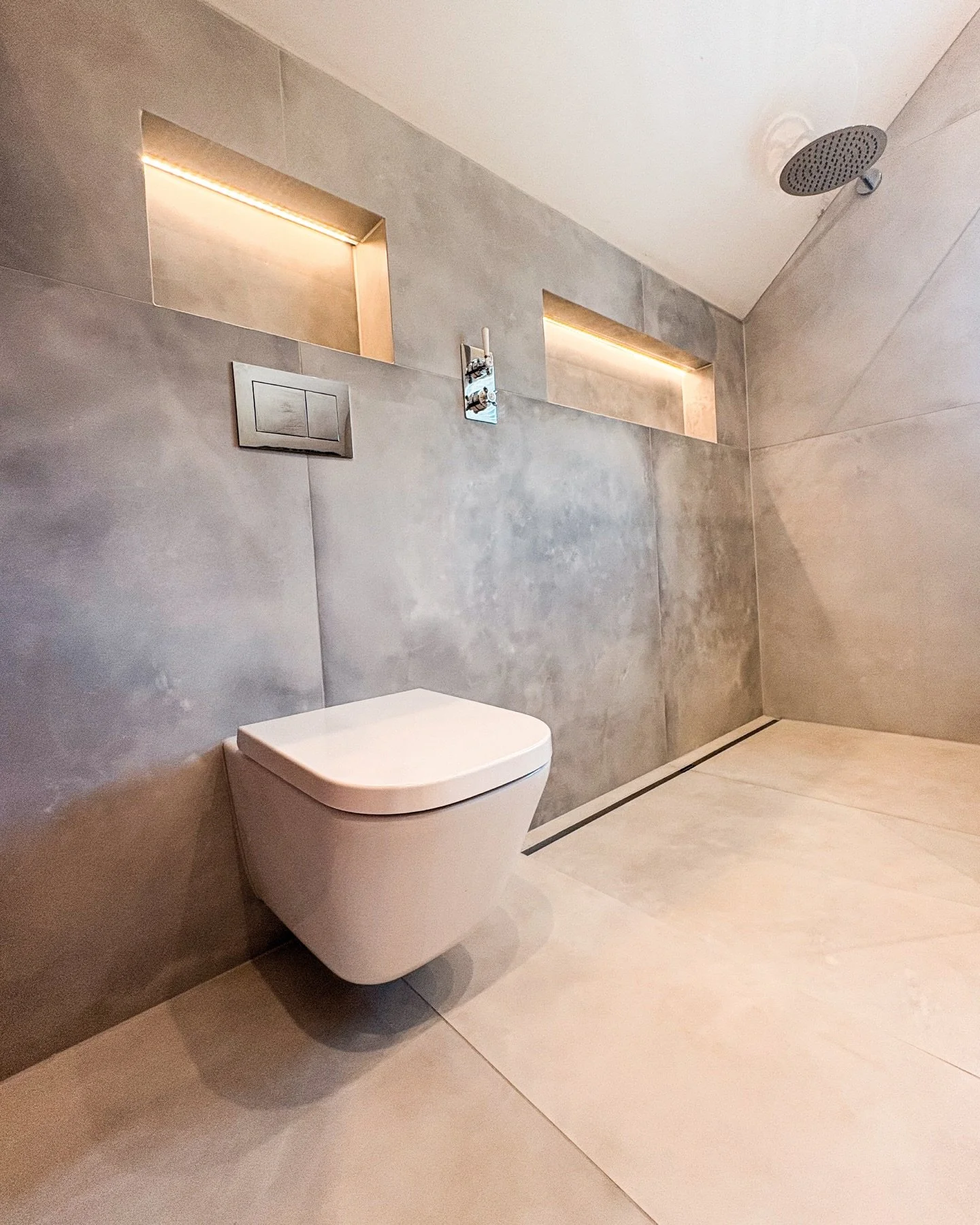 Full bathroom renovation completed in North Kilworth.

Large format tiling with mitred edges, a clean walk-in shower, and a freestanding copper bath all brought together with careful attention to detail. Recessed shelving with integrated lighting kee