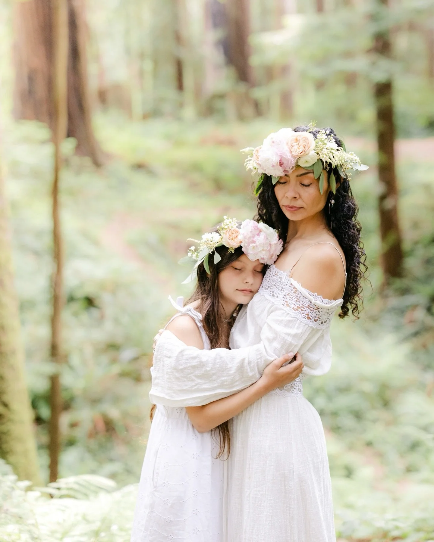 Soft light filtered through the redwoods as they walked hand in hand, their connection effortless and unmistakable. Floral crowns rested gently in their hair, both of them barefoot against the forest floor. Their love felt steady and secure &mdash; p