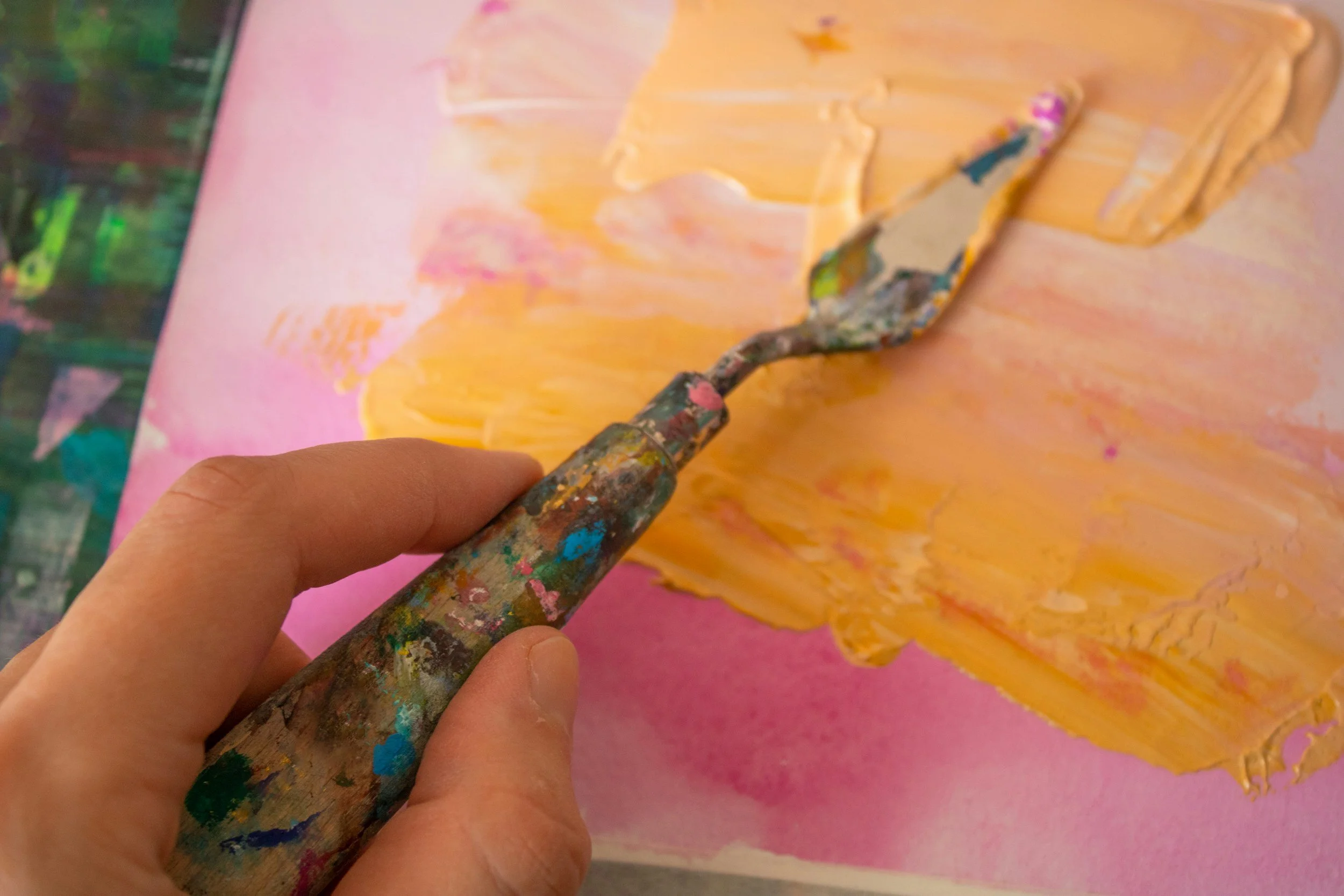 A hand creating loose scribble marks on paper, representing creative beginnings.