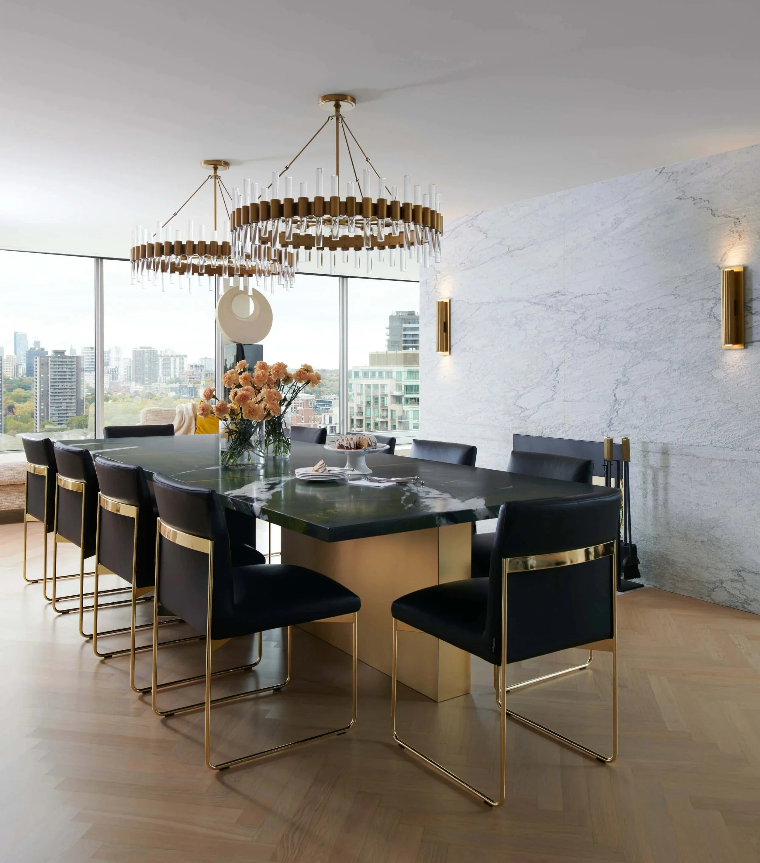 dining room + brass chandeliers + black dining chairs + city views + yorkville toronto