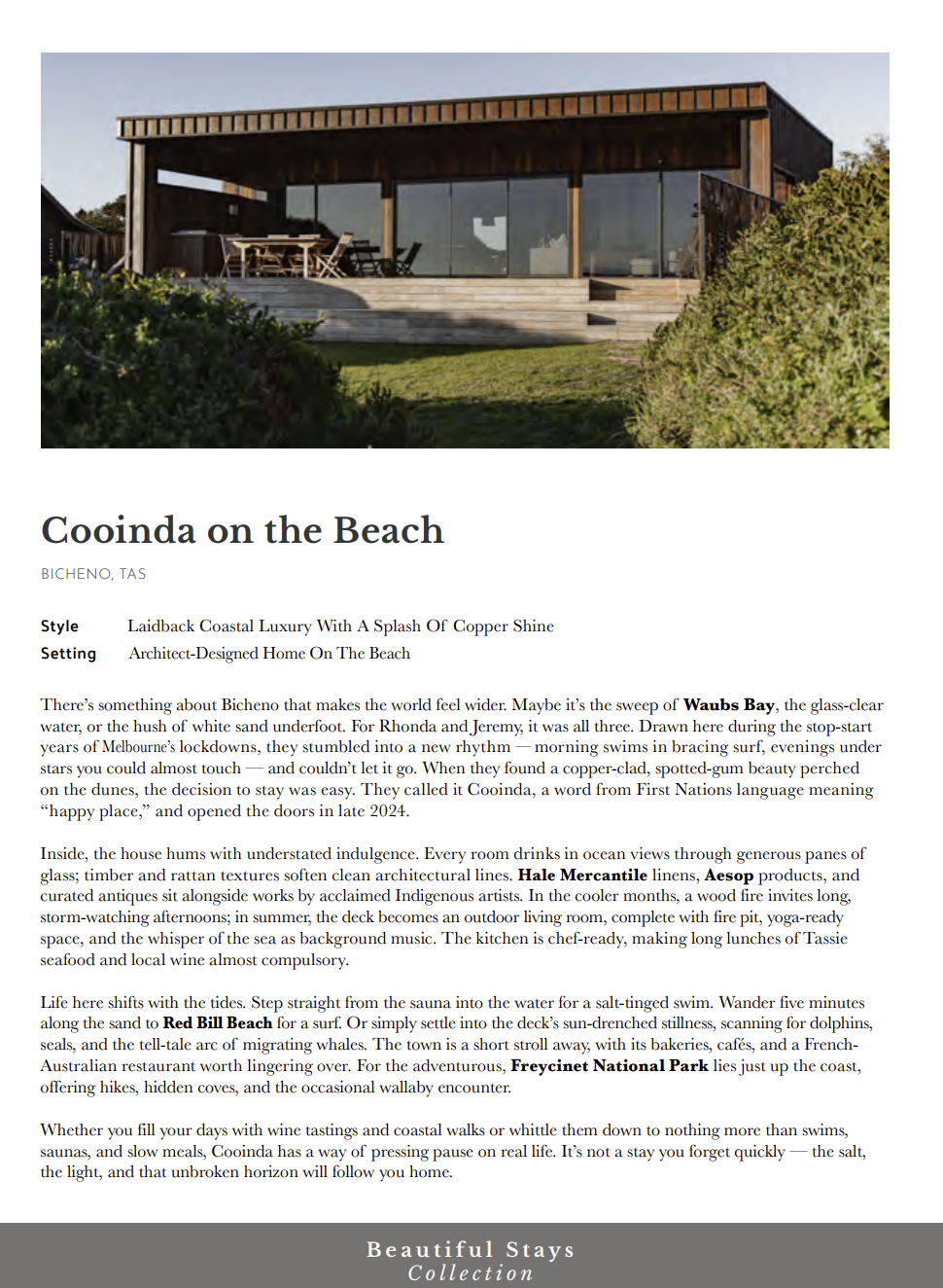 Beachfront luxury accommodation with large glass windows and wooden exterior, located on a grassy area with bushes, under a clear sky.