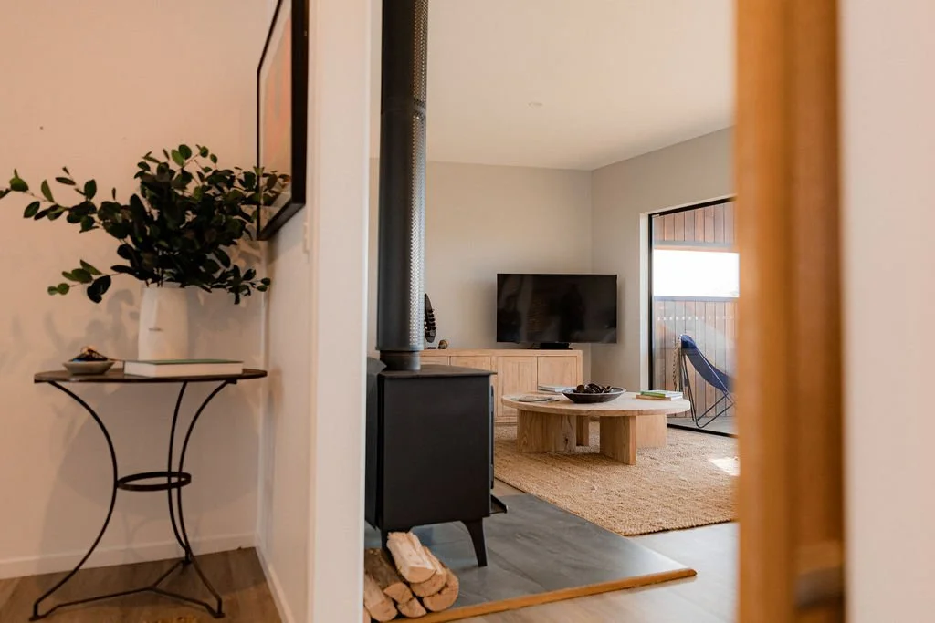 Modern lounge with fireplace at beachfront accommodation at Cooinda on the Beach in Bicheno, Tasmania.