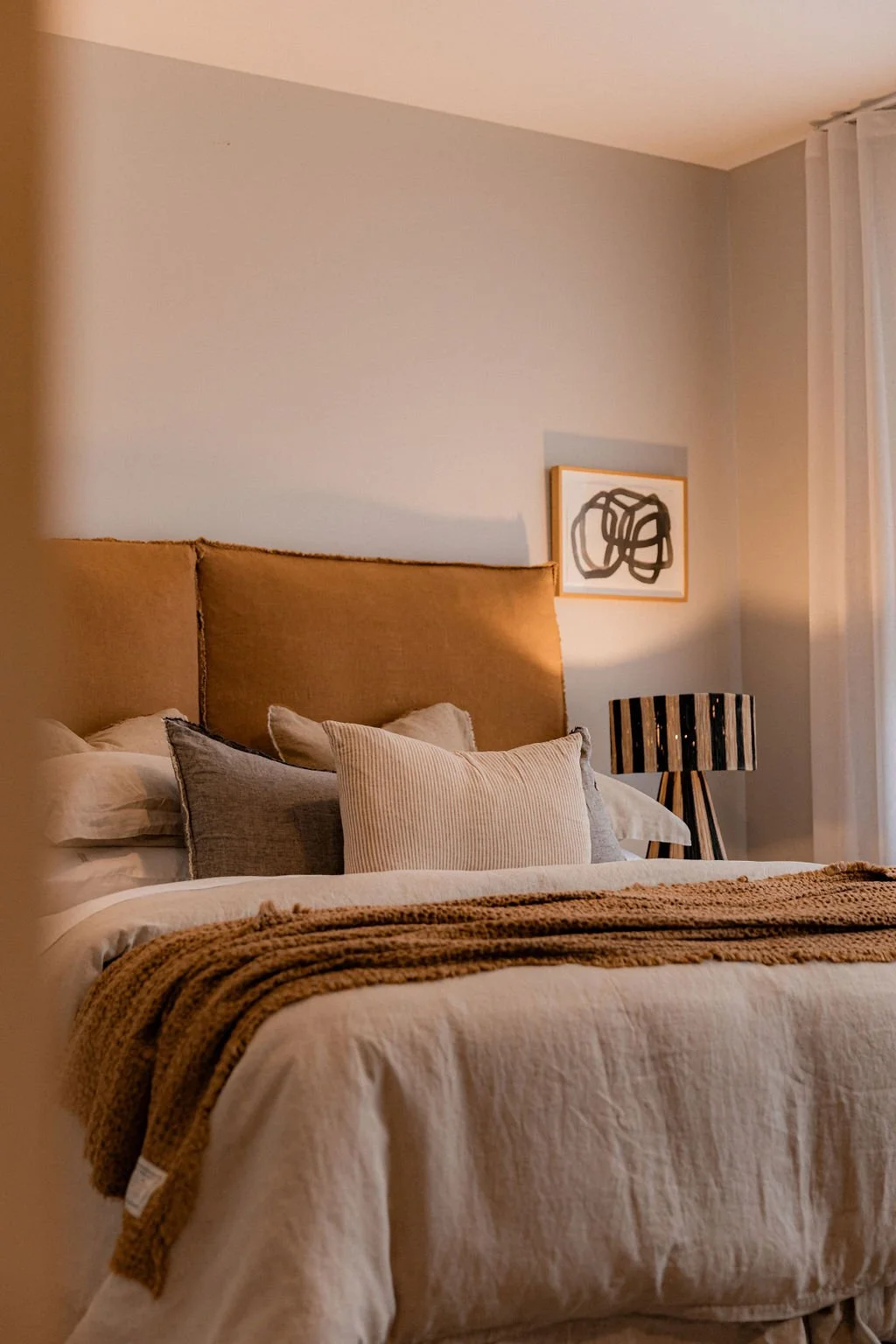 Cozy beachfront bedroom at Cooinda on the Beach  with soft evening lighting and ocean view of East Coast Tasmania.