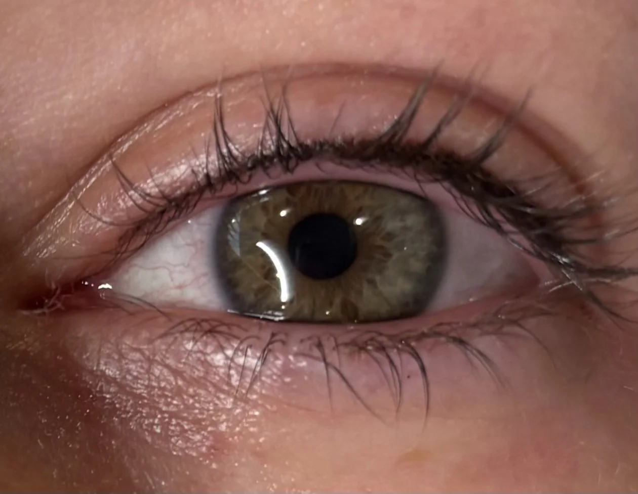 close up of a woman's eye white woman with green eye and black/purple eyeliner