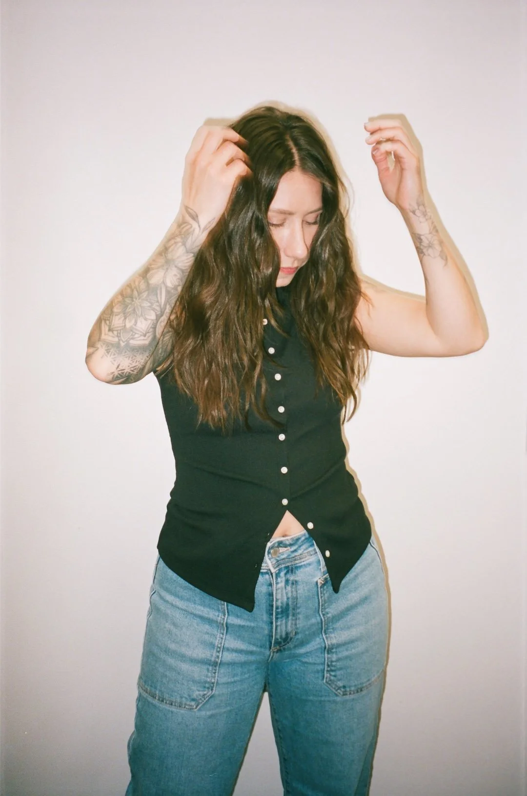 Jennifer Mottola, owner of Hair by Jen in Charlotte N.C., which is a hair salon that specializes in brunettes as well as extensions. This photo is of owner Jennifer Mottola standing in front of a white wall in her Charlotte hair salon for brunettes