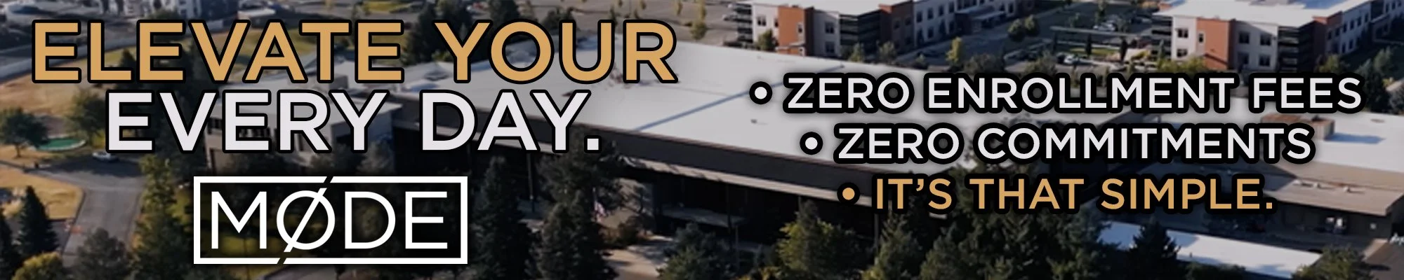 An aerial view of a modern residential or commercial building complex with trees and pathways. Liberty Lake.