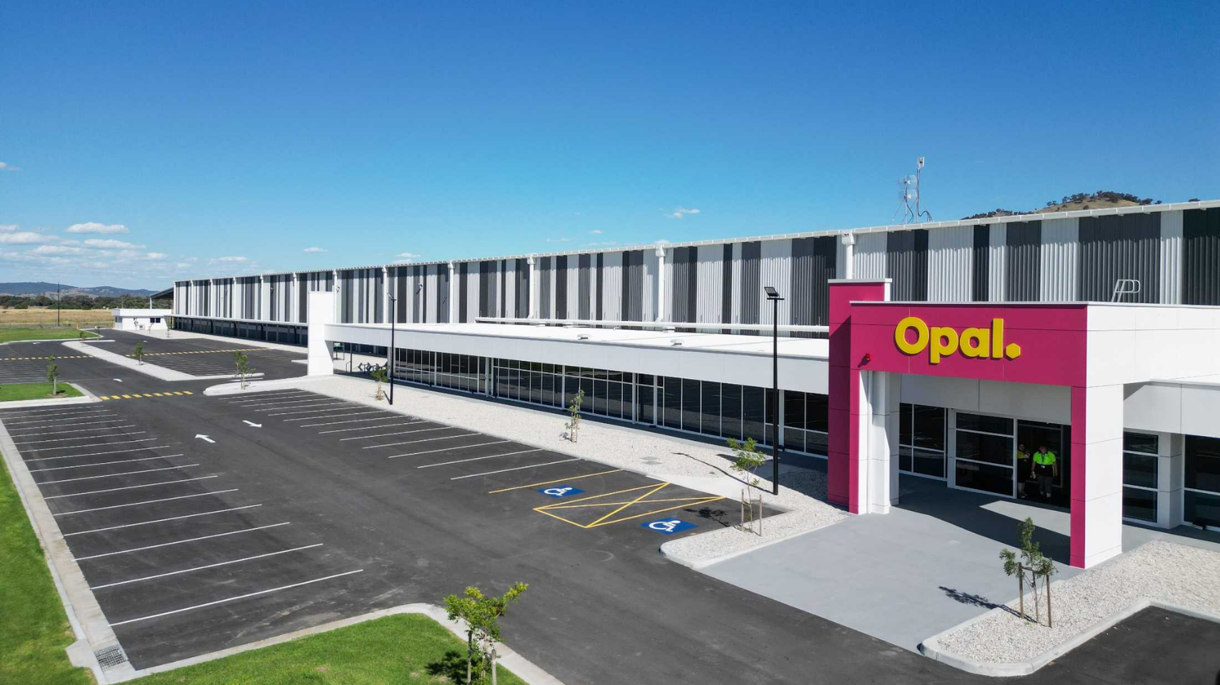 Large commercial building with a parking lot, including several handicapped parking spaces, and the sign 
