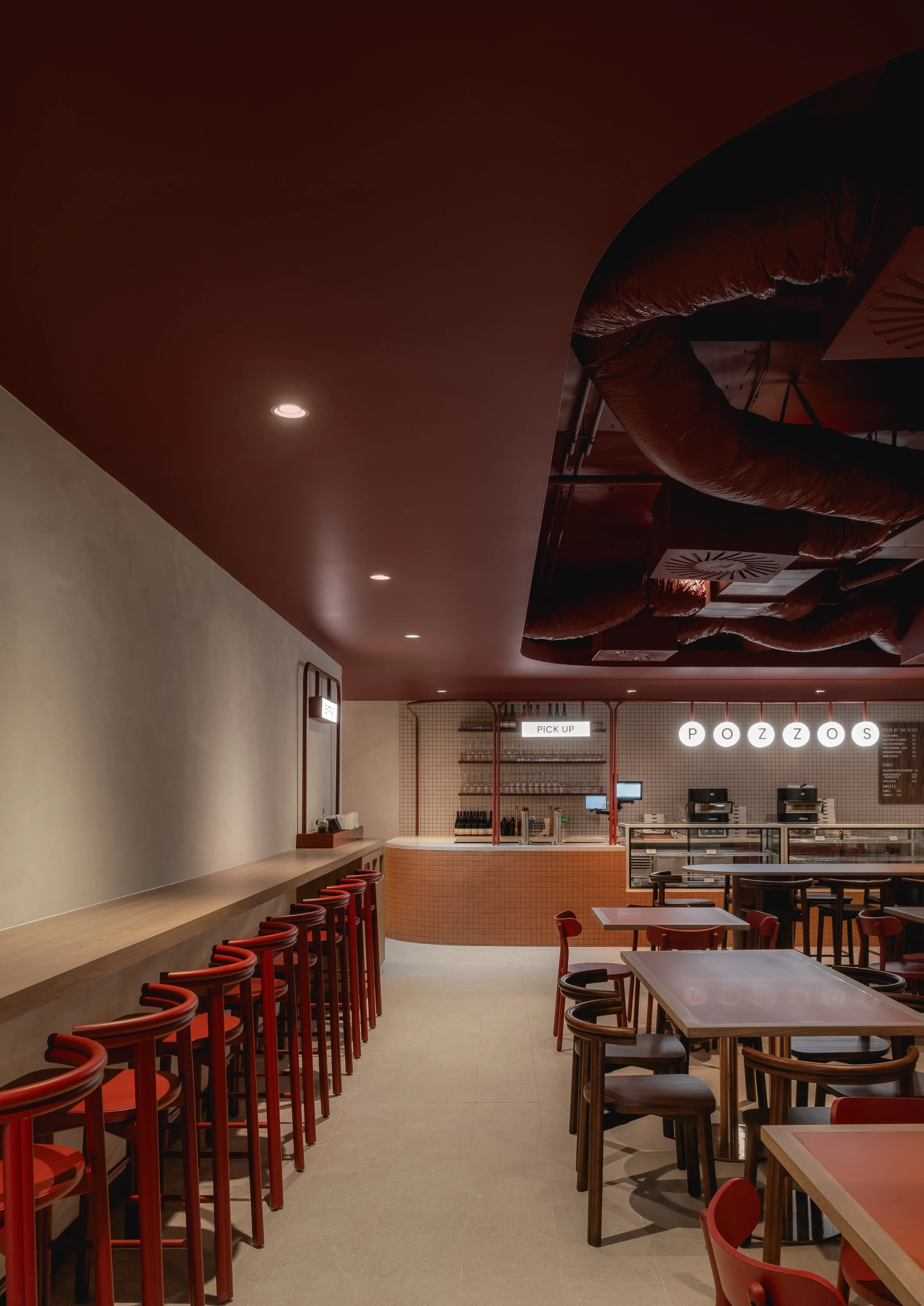 Restaurant interior featuring burgundy banquette seating and a rich tonal material palette.