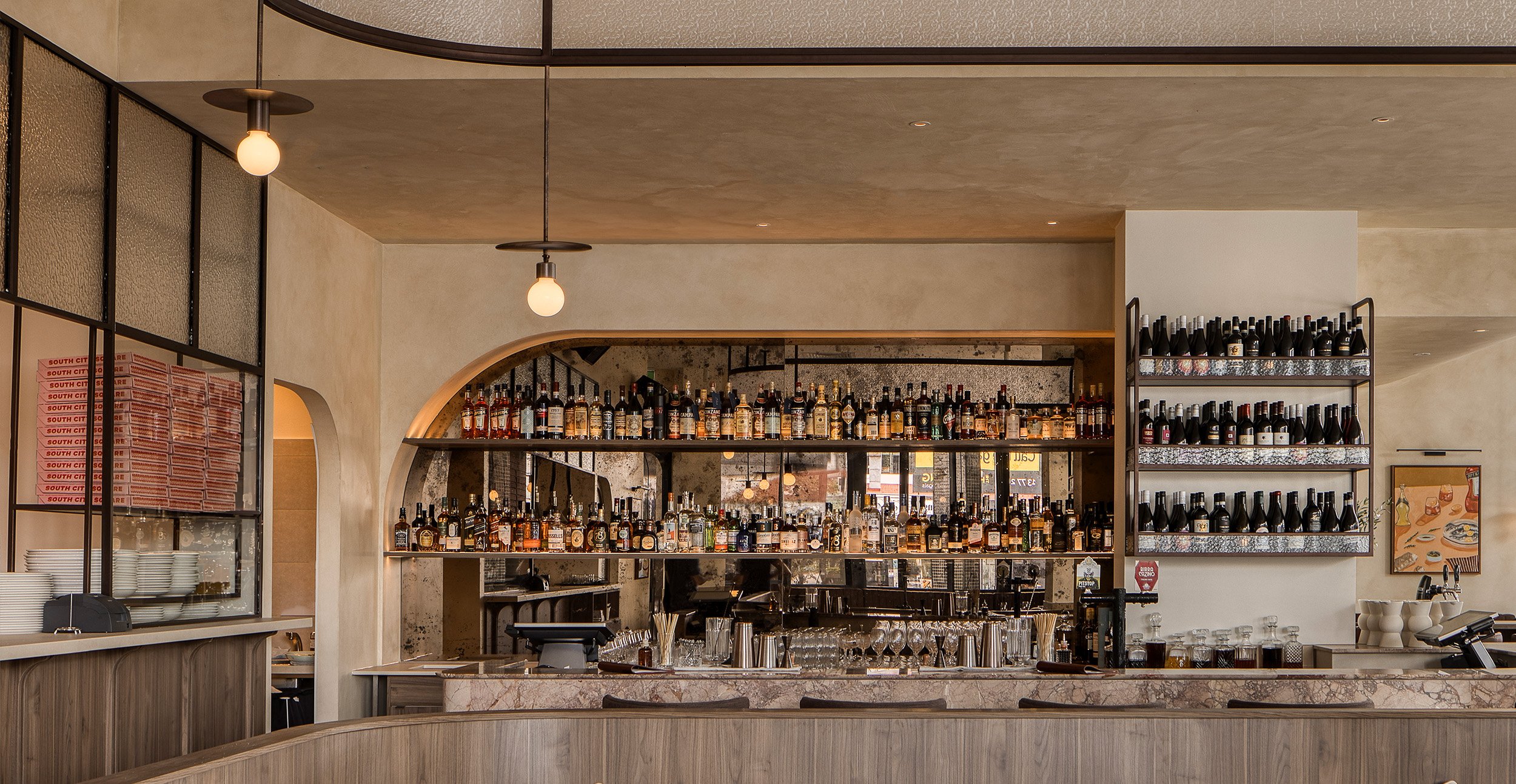 Hospitality bar design with marble top, timber finishes and warm atmospheric lighting