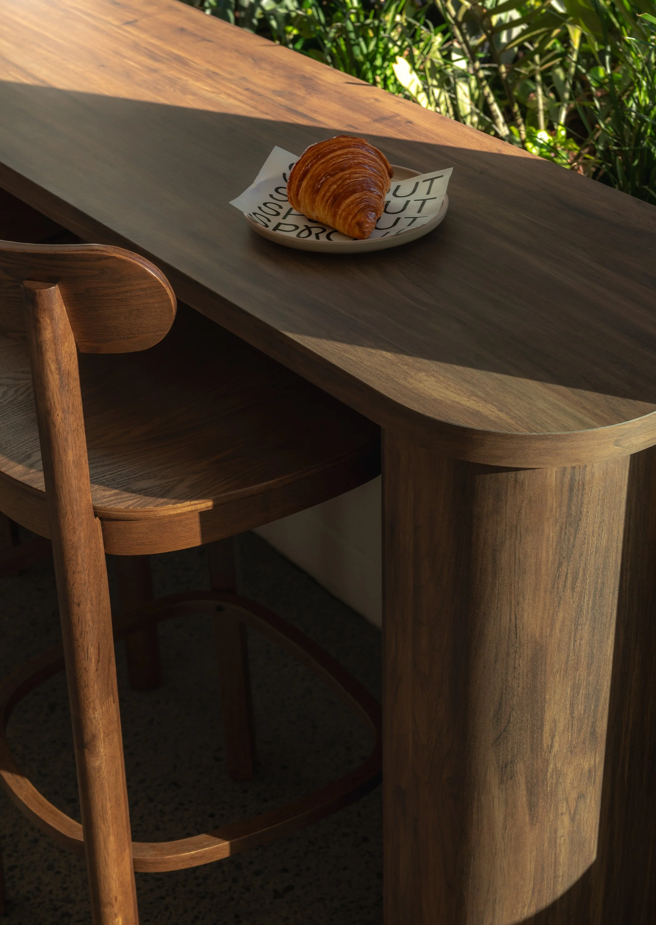 Contemporary bakery seating with warm timber detailing, minimalist furniture and hospitality-focused interior design