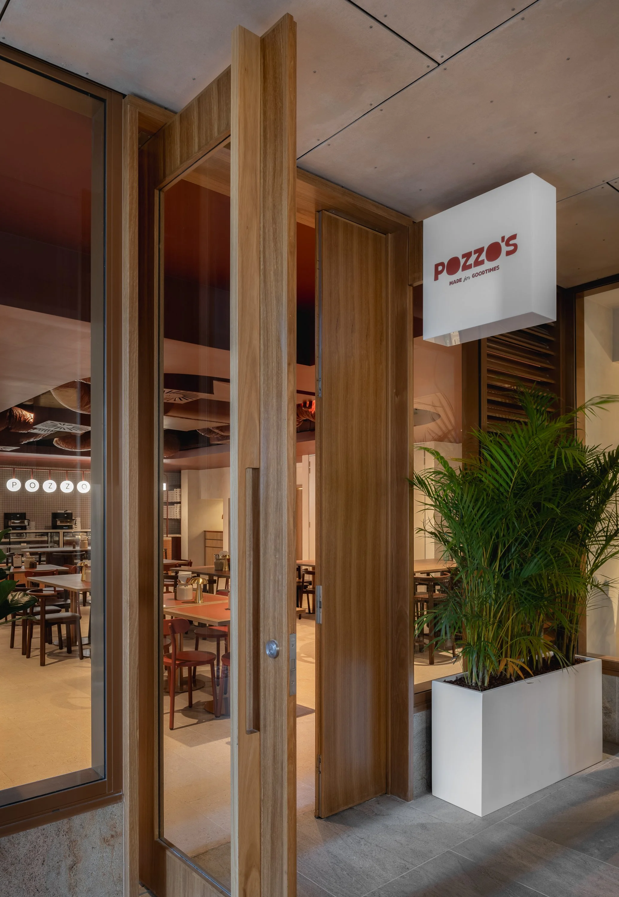 Timber-framed restaurant entry with glazing and integrated signage.