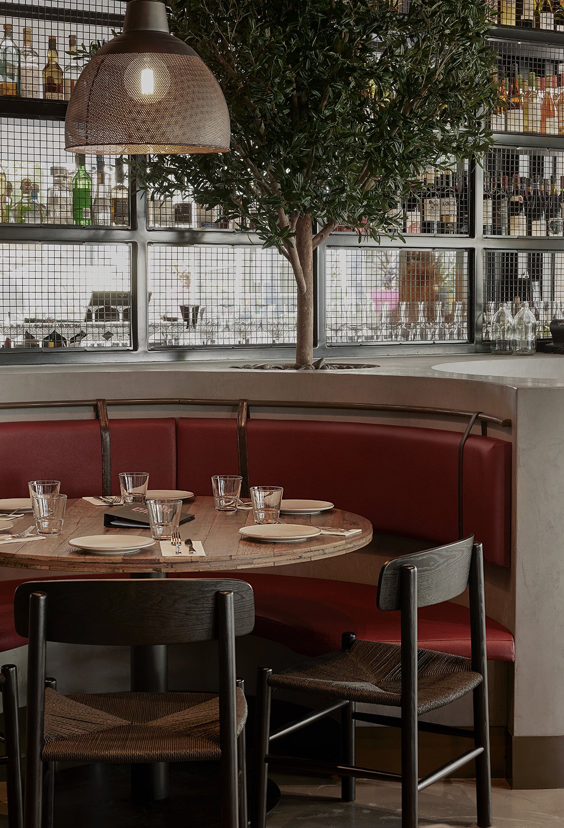 Semi-circular booth seating with rich upholstery and warm ambient lighting