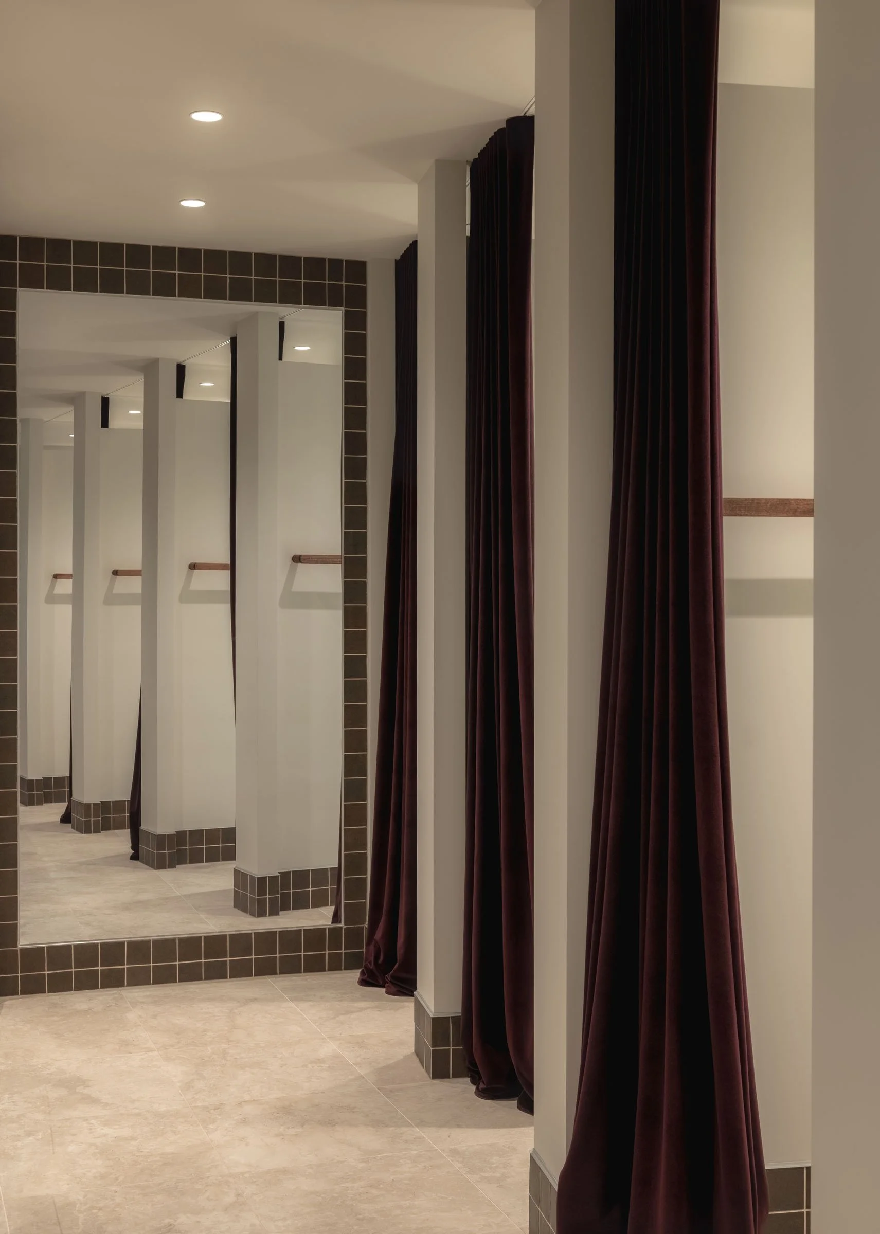 Boutique fitting rooms at Sabo Sunshine Plaza featuring dark curtains, tiled detailing and warm contemporary retail interiors.