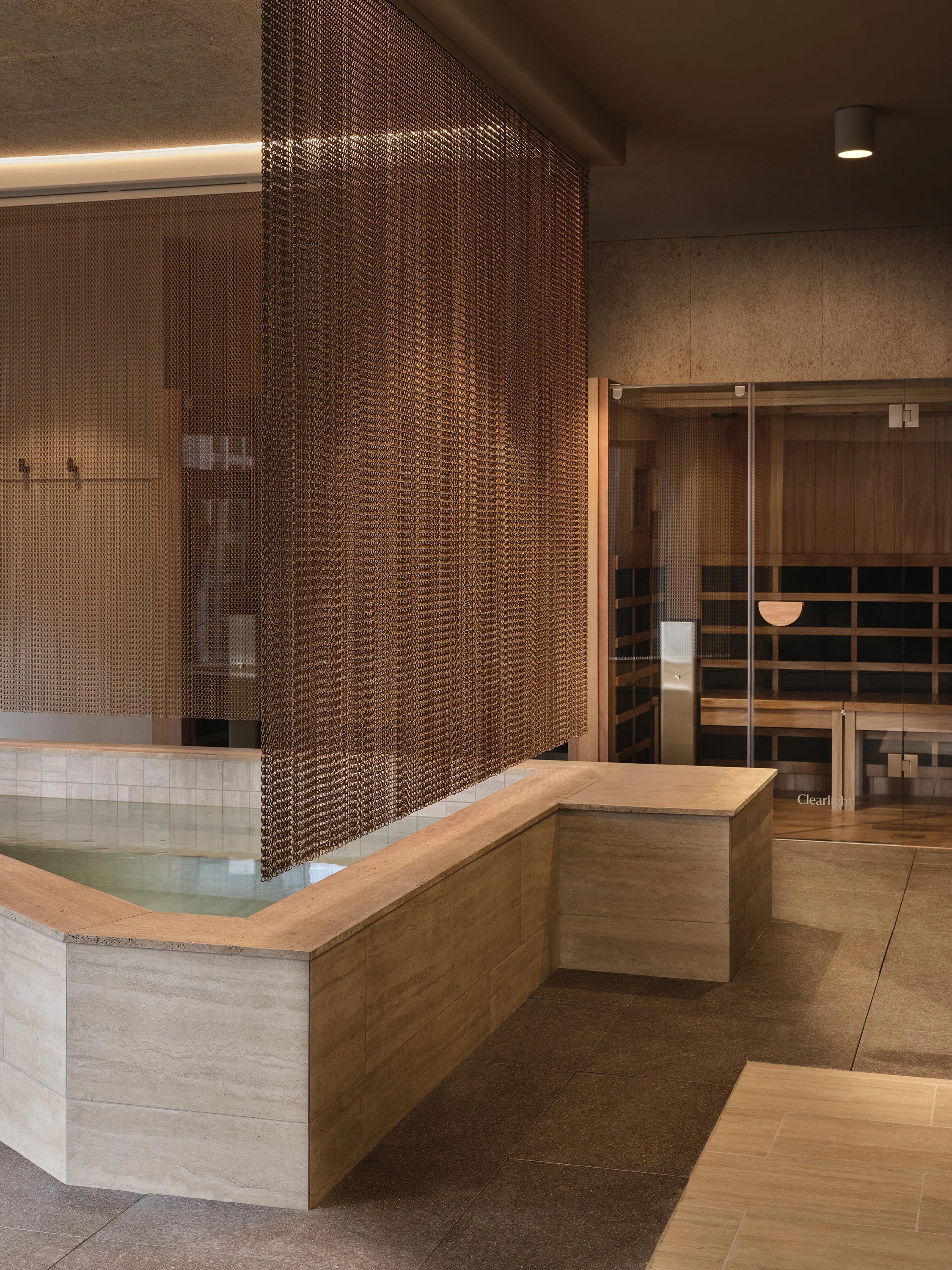Magnesium plunge pool and sauna wellness space design with natural stone and city views in Melbourne, Docklands.