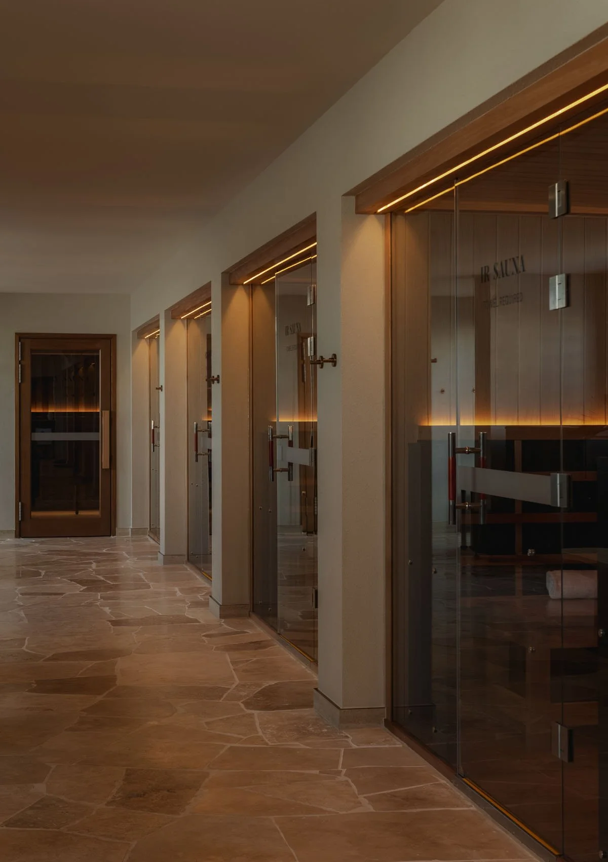 Timber-lined sauna with warm ambient lighting and layered seating.