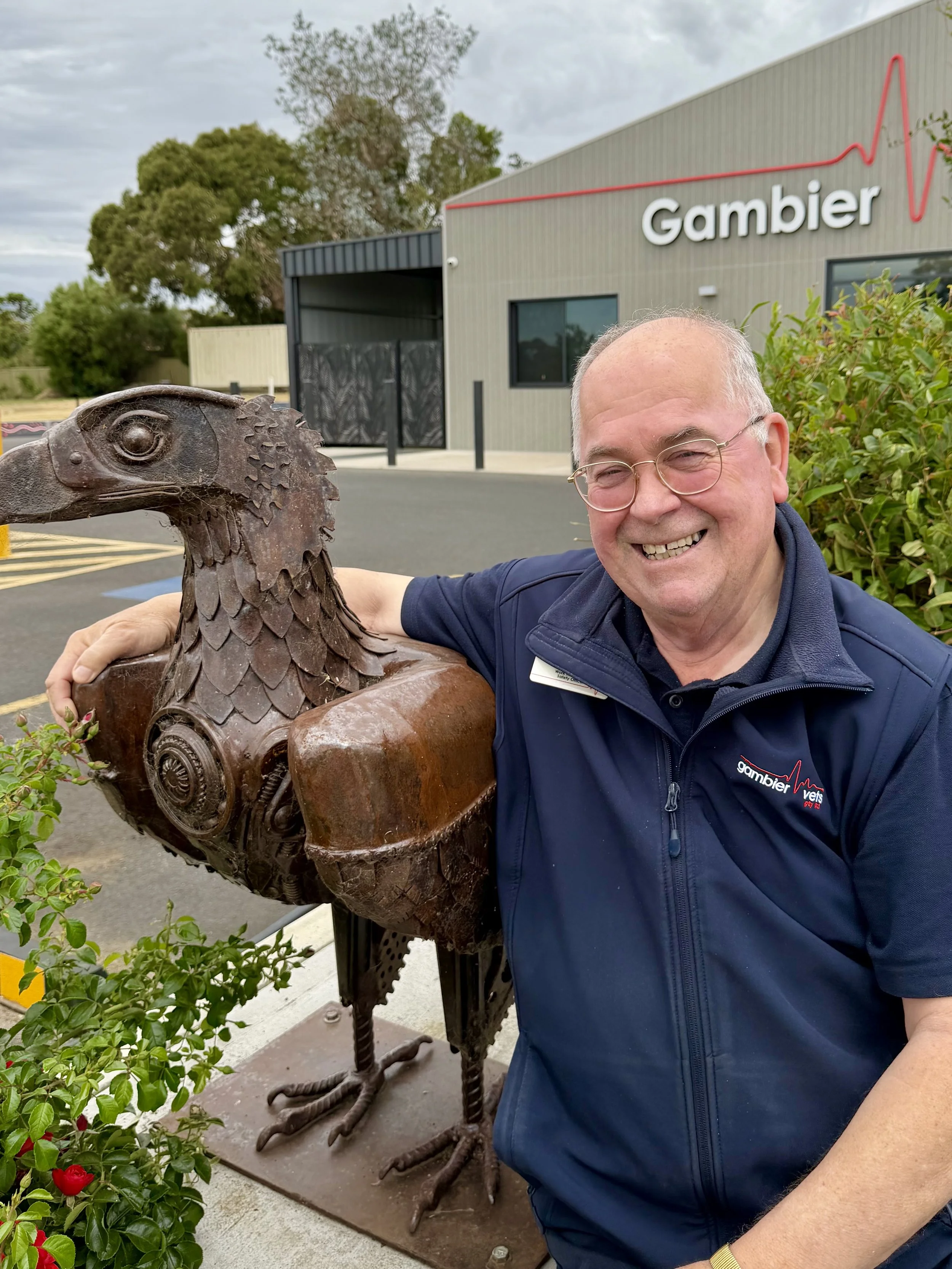 A man sitting at a desk with a computer monitor in the background.
