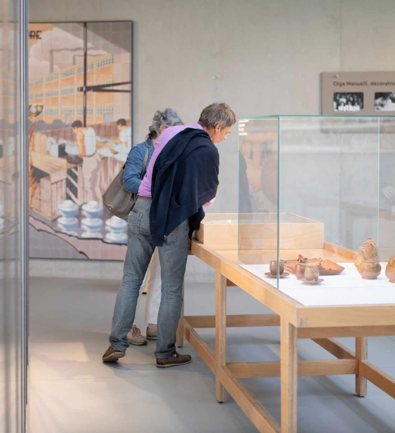 Deux personnes regardant des objets archéologiques dans une vitrine d'exposition dans un musée.