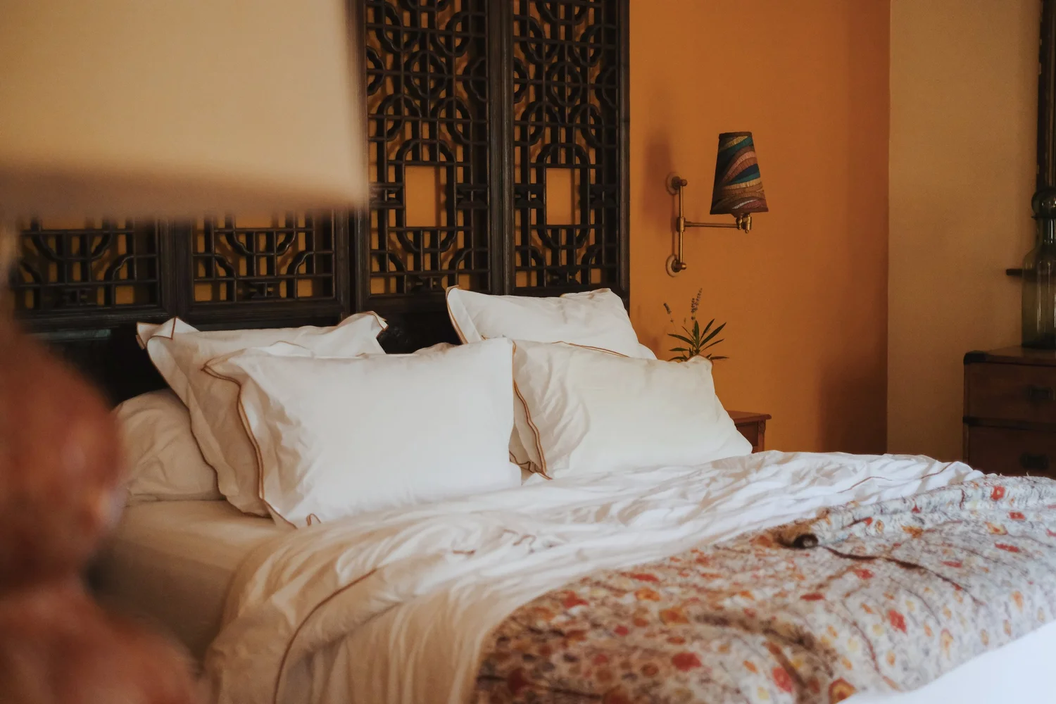 Ochre bedroom with a carved screen at Domaine Madrona