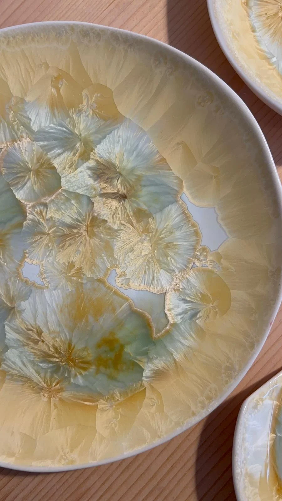 Ceramic plate with mineral and porcelain, in shades of yellow, gold, and cream, resembling flower petals or natural textures.