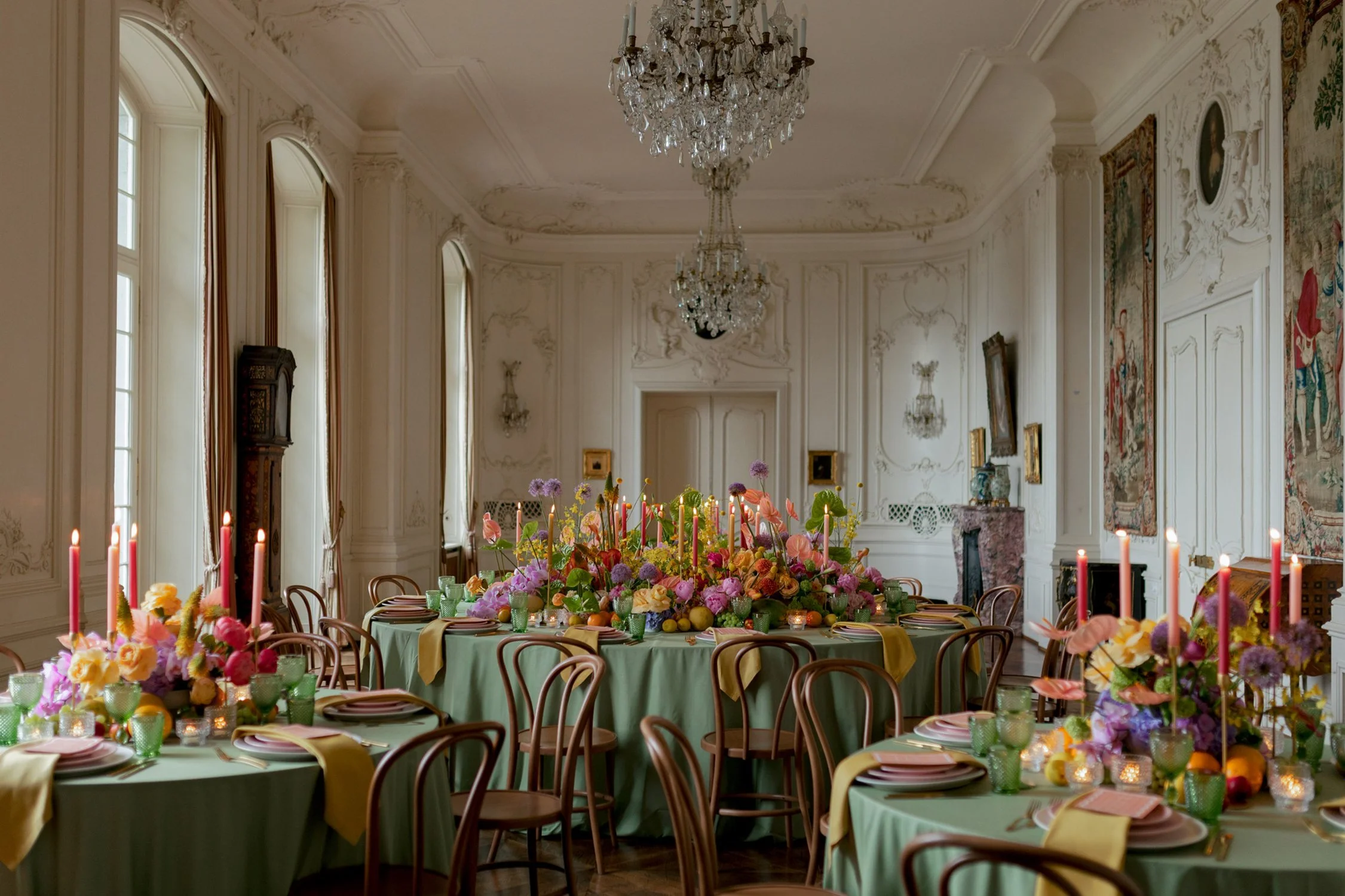 Grüne Tische sind eingedeckt und mit vielen bunten Blumen und Kerzen geschmückt.