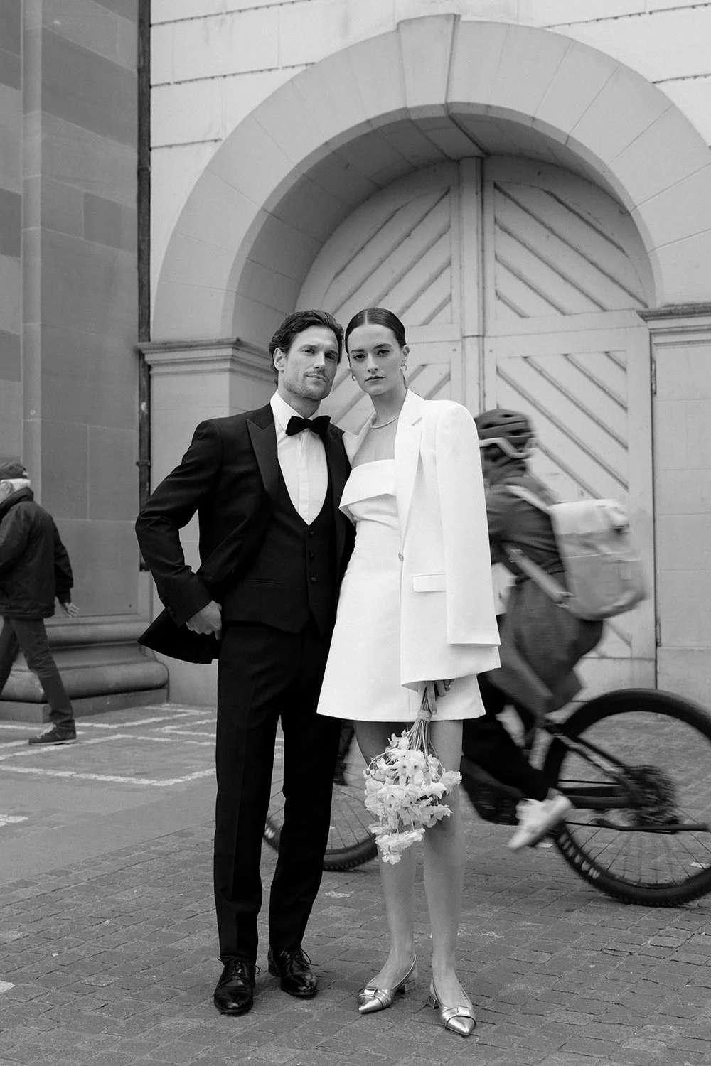 Ein Brautpaar steht umarmend vor einer Kirche.