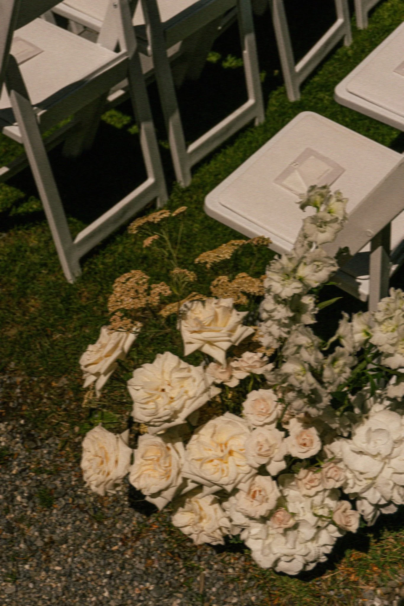 Ein Blumenbouquet ist neben Stühlen am Boden arrangiert in Lachstönen.