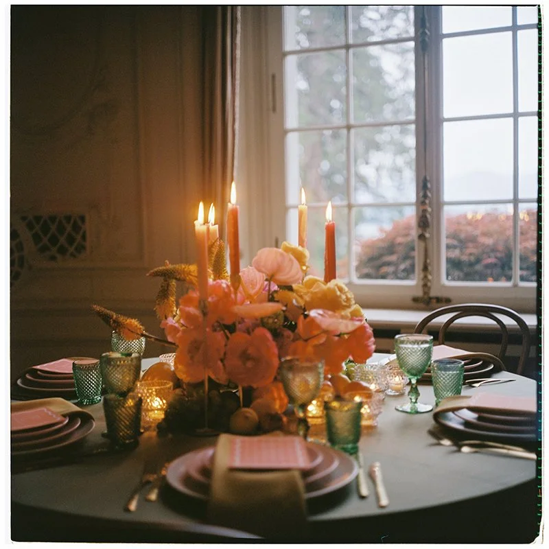 In der Mitte eines kleinen Tisches steht ein buntes Blumenarrangement.