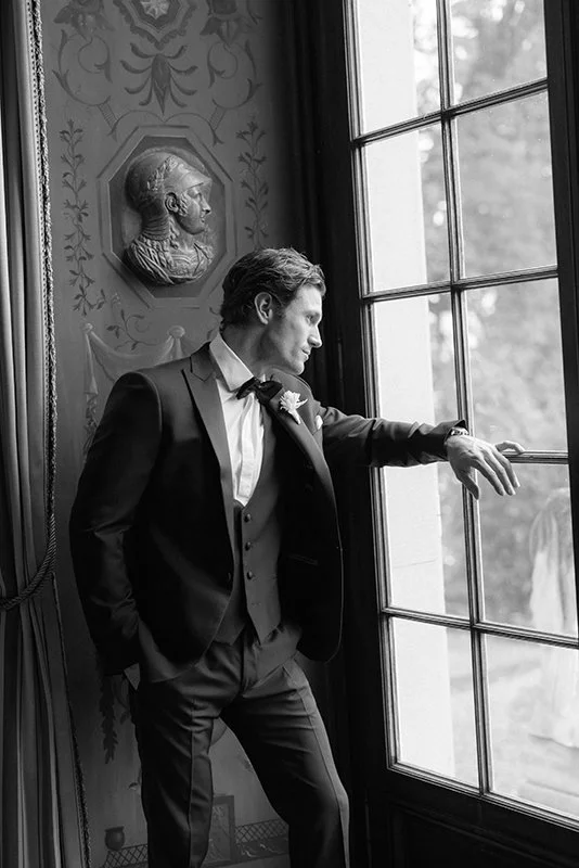 Ein Mann im Anzug schaut nachdenklich aus einem grossen Fenster.