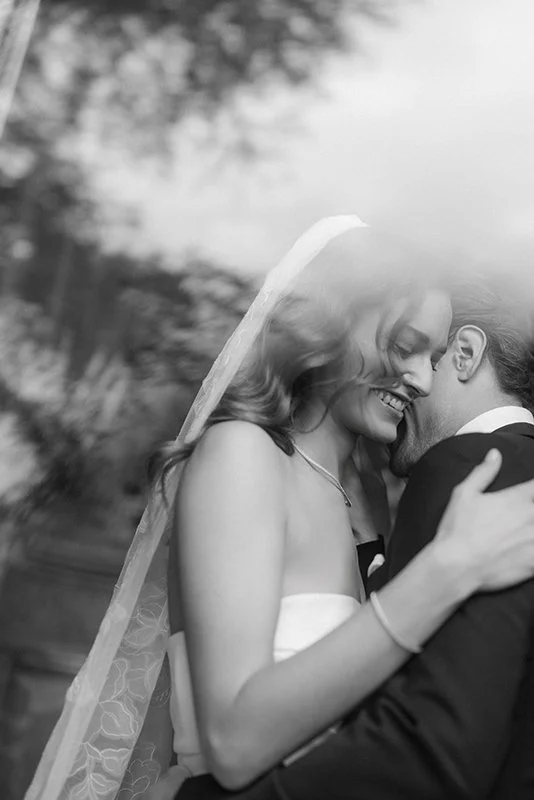 Eine lachende Braut umarmt ihren Mann.