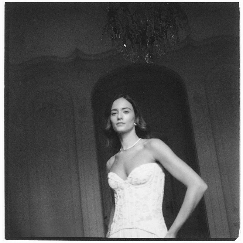 Eine Braut steht in einem weissen Kleid im Raum.