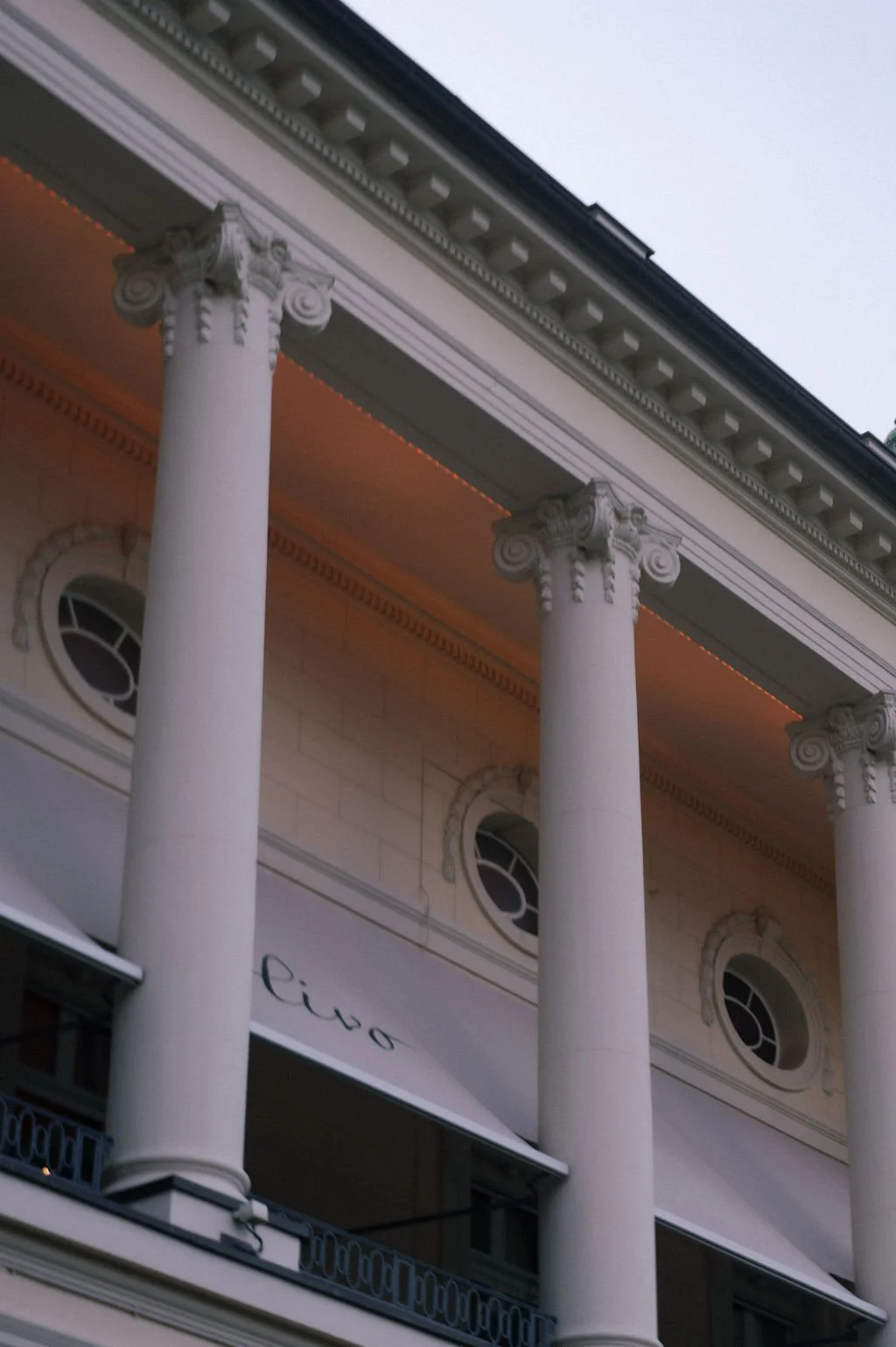 Eine Fassade von einem Haus mit weissen Säulen.