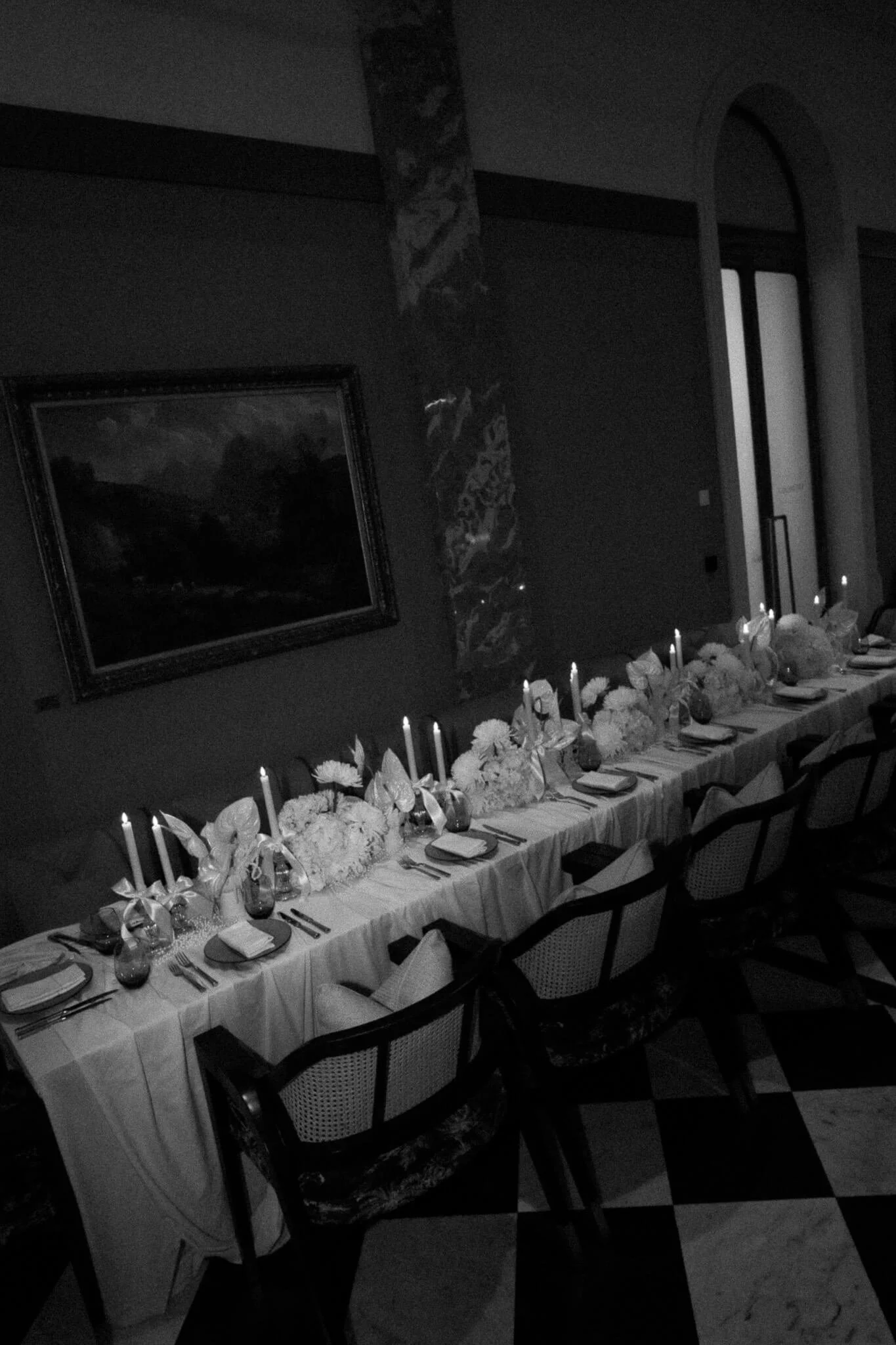 Ein eingedeckter Tisch mit weissen Blumen und Stabkerzen.