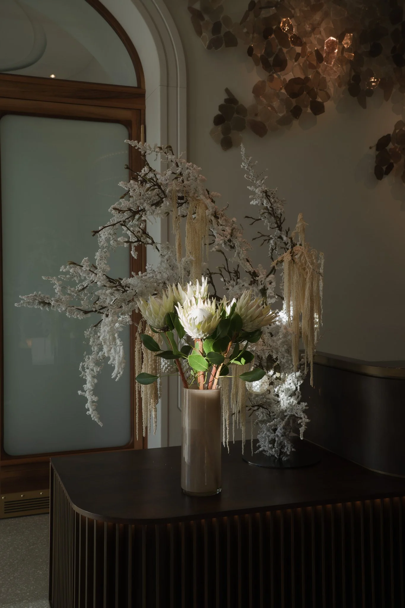 Weisse Blumen stehen auf einem Tisch im Sonnenlicht. 