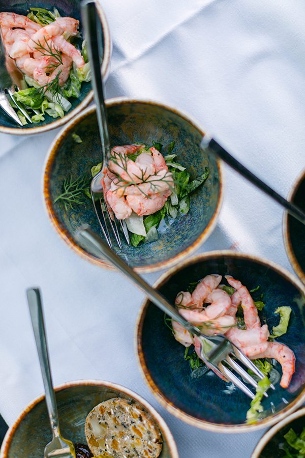 Grüne Schalen sind gefüllt mit Shrimps und Gabeln.