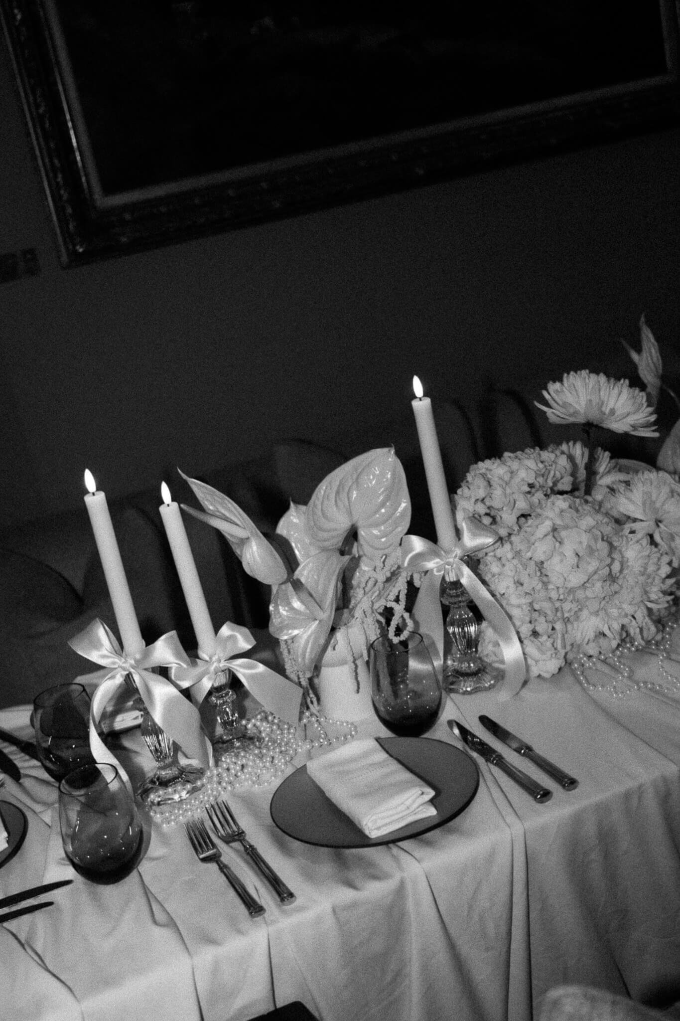 Eine Dekoration aus Kerzen mit Maschen und Blumen in weiss.