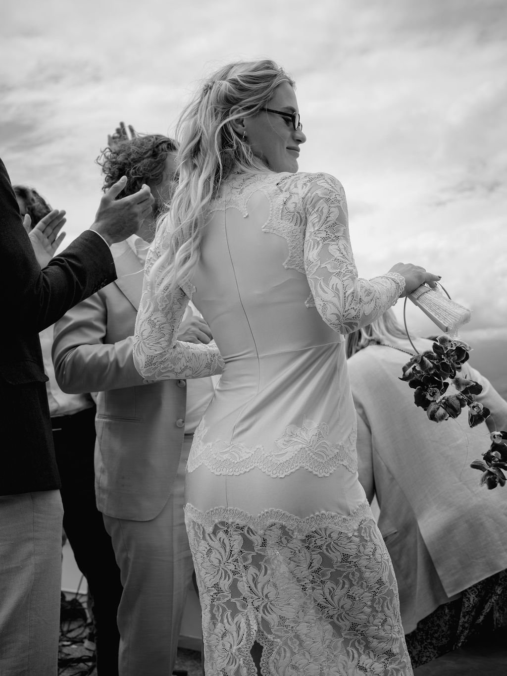 Eine Braut tanzt in ihrem Brautkleid zwischen Menschen.