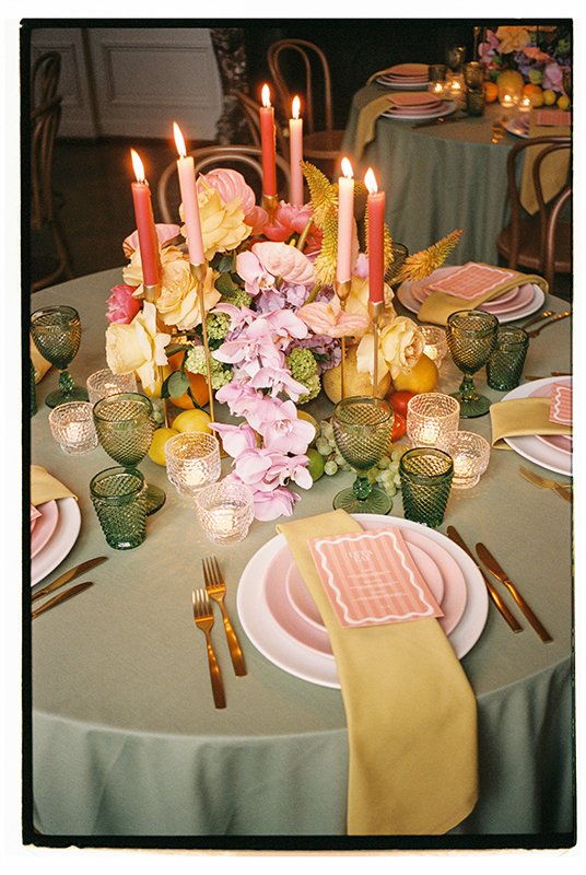 Auf einem hellgrünen Tisch steht ein buntes Blumenarrangement.