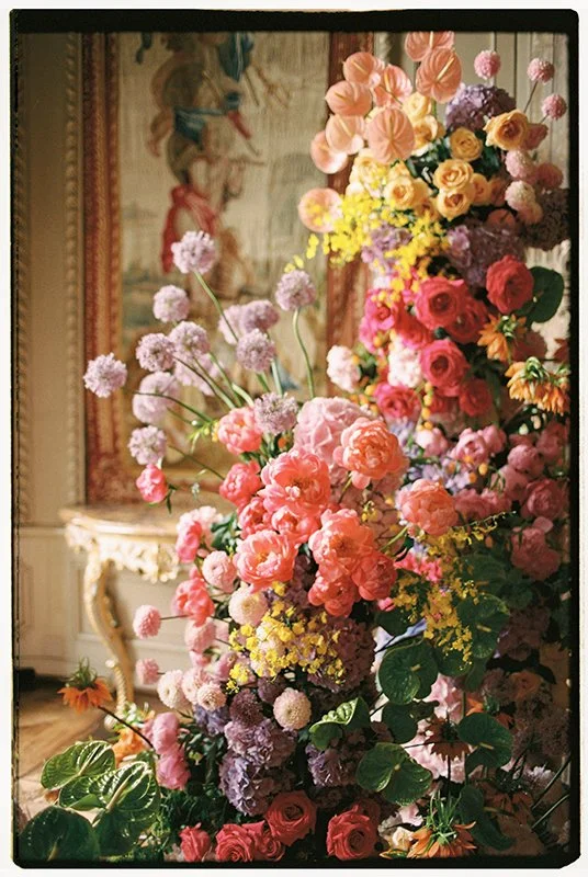 Bunte Blumen sind zu einem Gesteck arrangiert in einem hellen Raum.